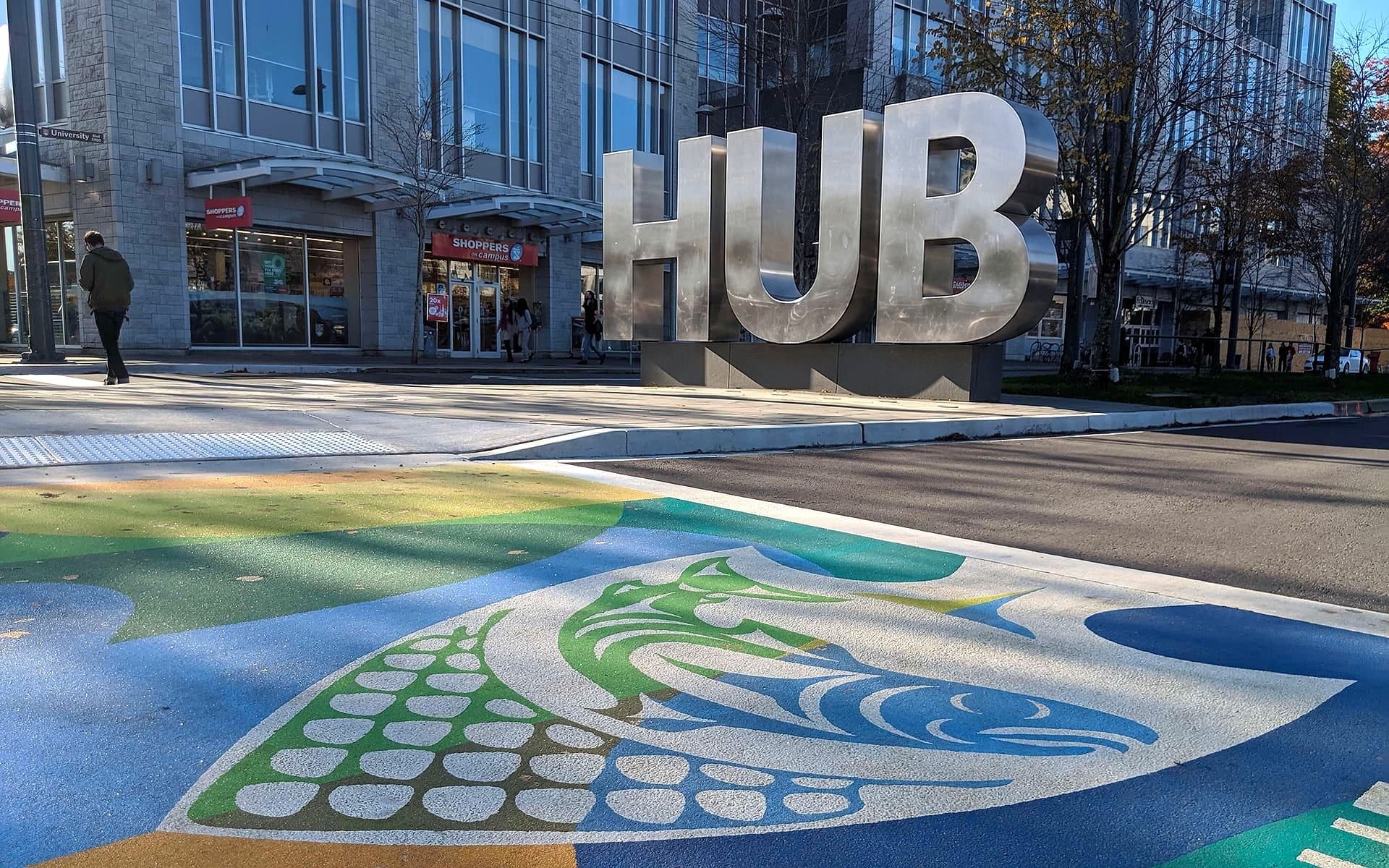 The UBC Musqueam crosswalk at the University of British Columbia campus entrance in Vancouver: Coast Salish artwork rendered in coloured pavement by HUB Surface Systems