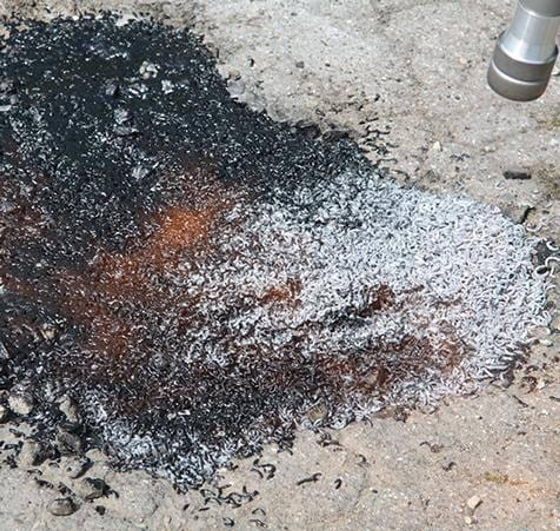 AggreFill aggregate and white ChipFill granules in a pothole, a repair in progress