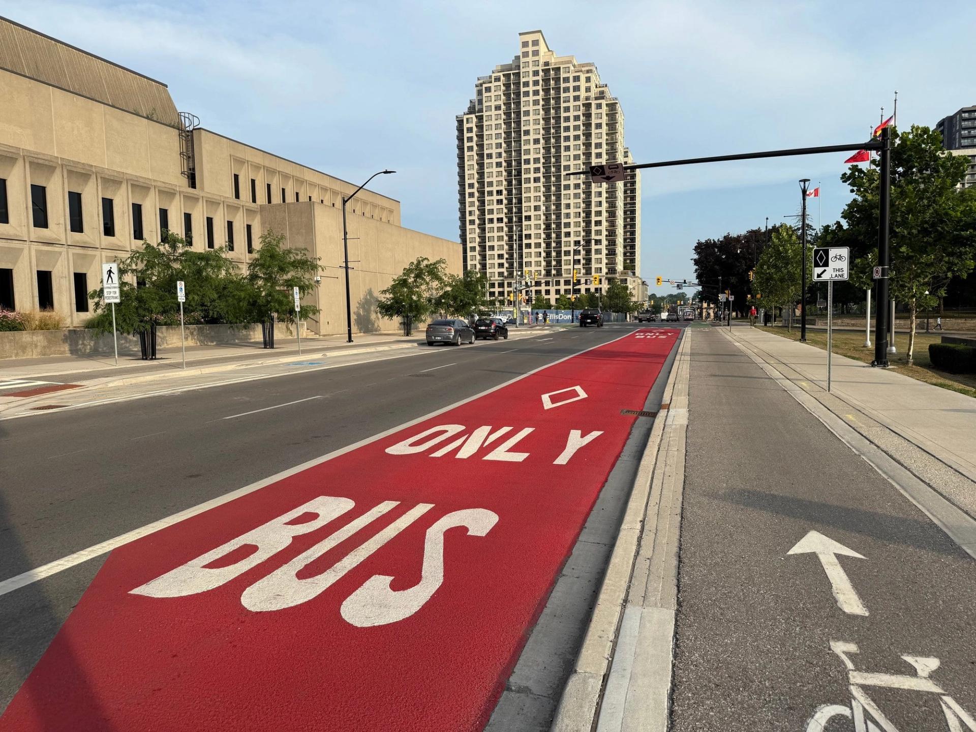 MMAX red bus-only lane: BUS ONLY legend on MMA methyl methacrylate coloured transit lane in London, Ontario