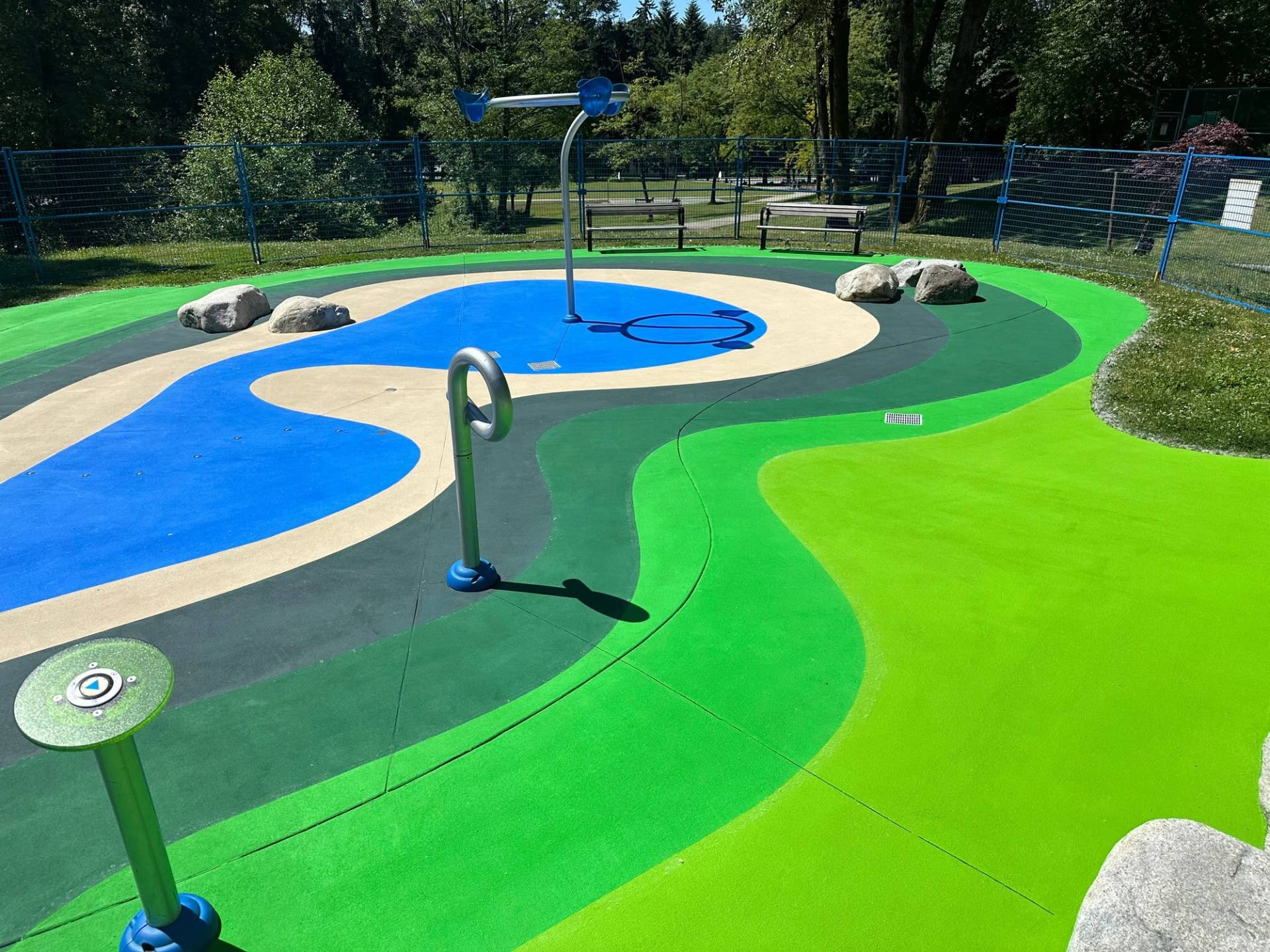 Splash pad surfacing in slip-resistant coloured surface coating at a park spray pad, Canada