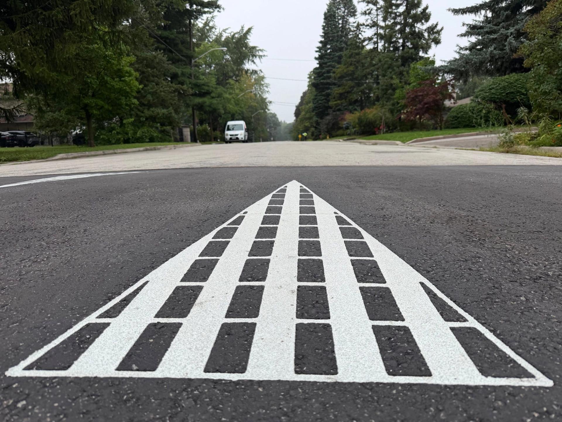 DuraTherm inlaid thermoplastic in preformed thermoplastic inlaid flush with the asphalt at a courtyard, Canada
