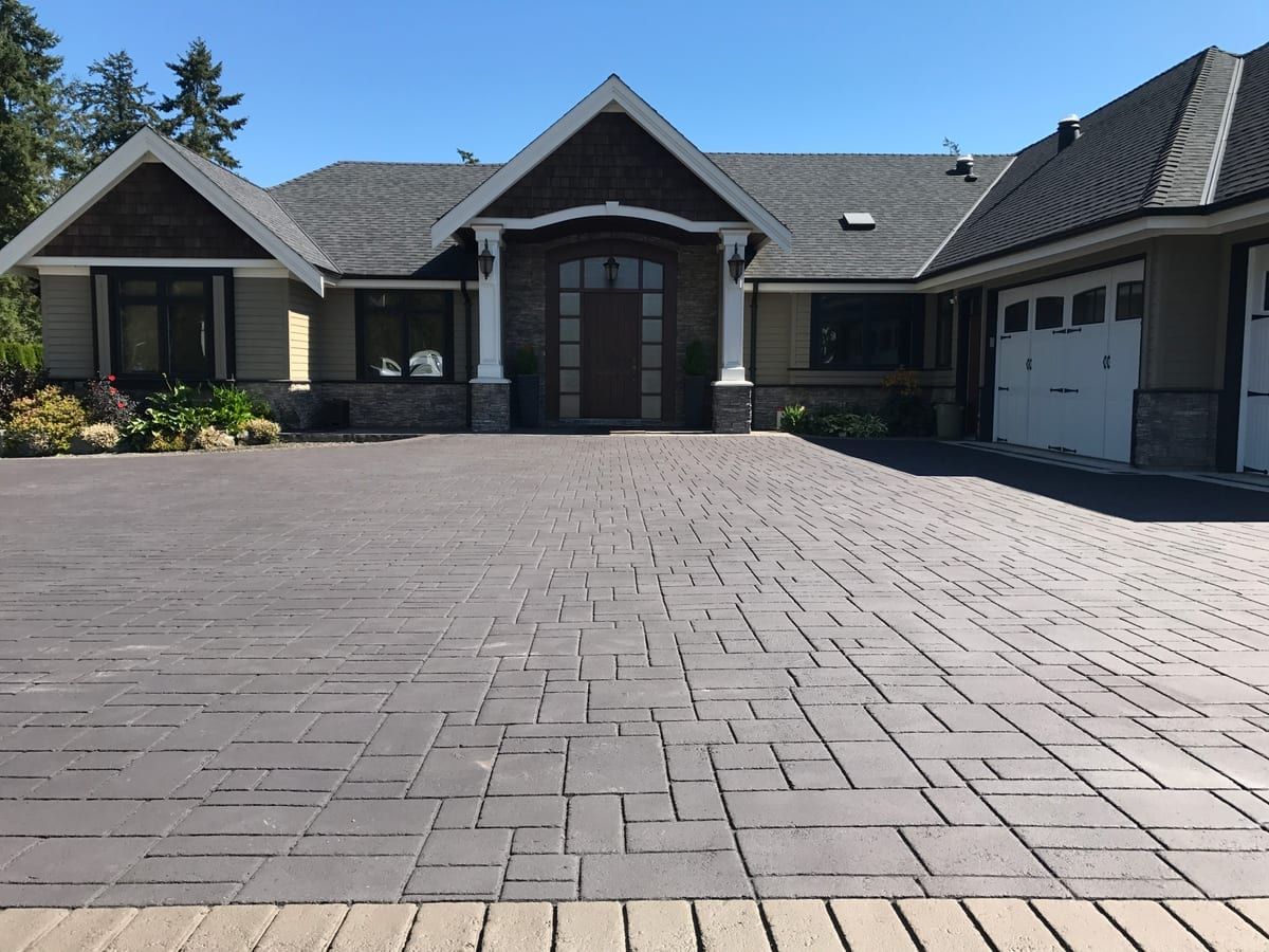 Charcoal herringbone stamped asphalt on a craftsman home driveway