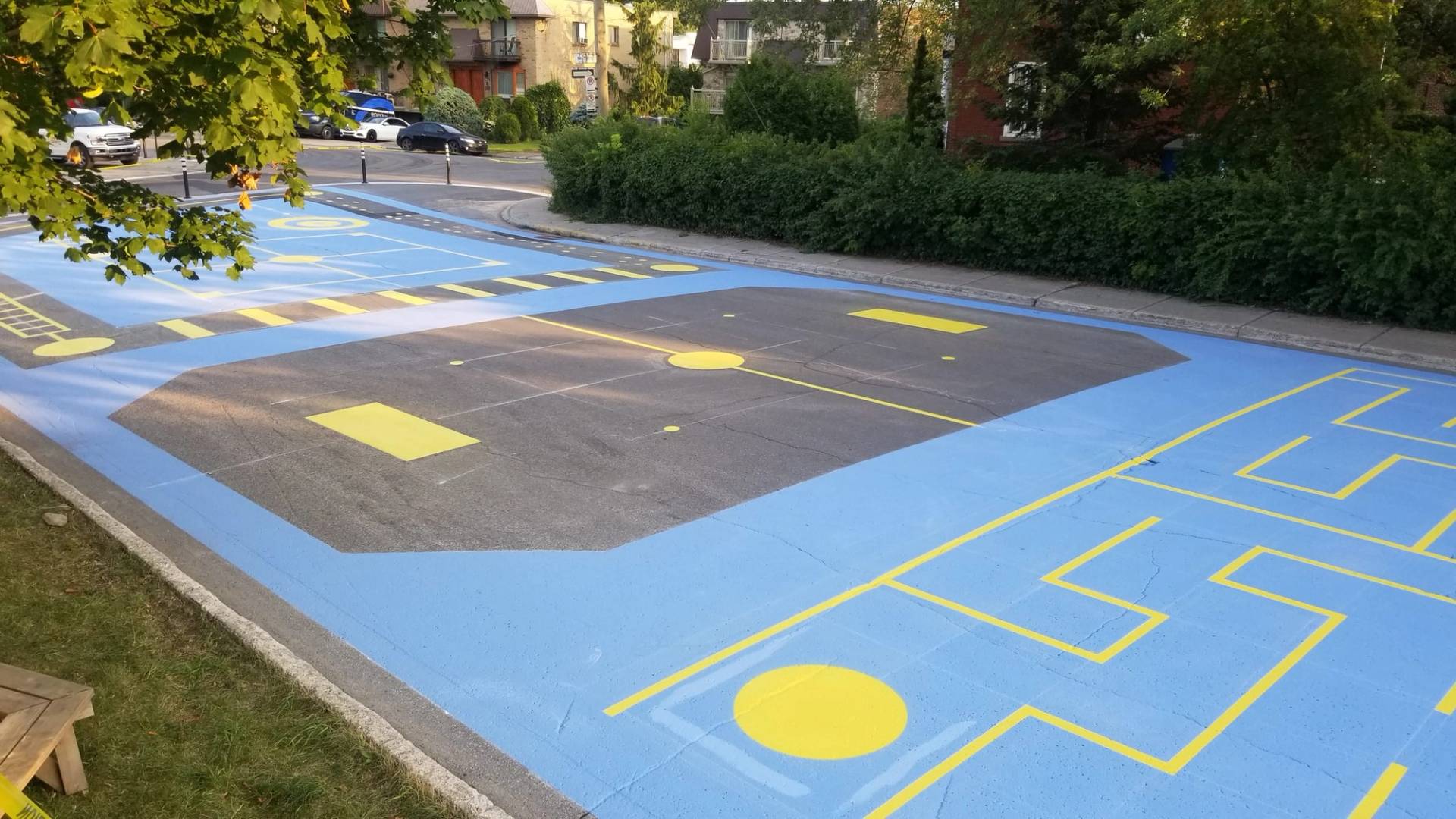 Playground surface graphics in coloured pavement coating and preformed play graphics at a park play zone, Canada