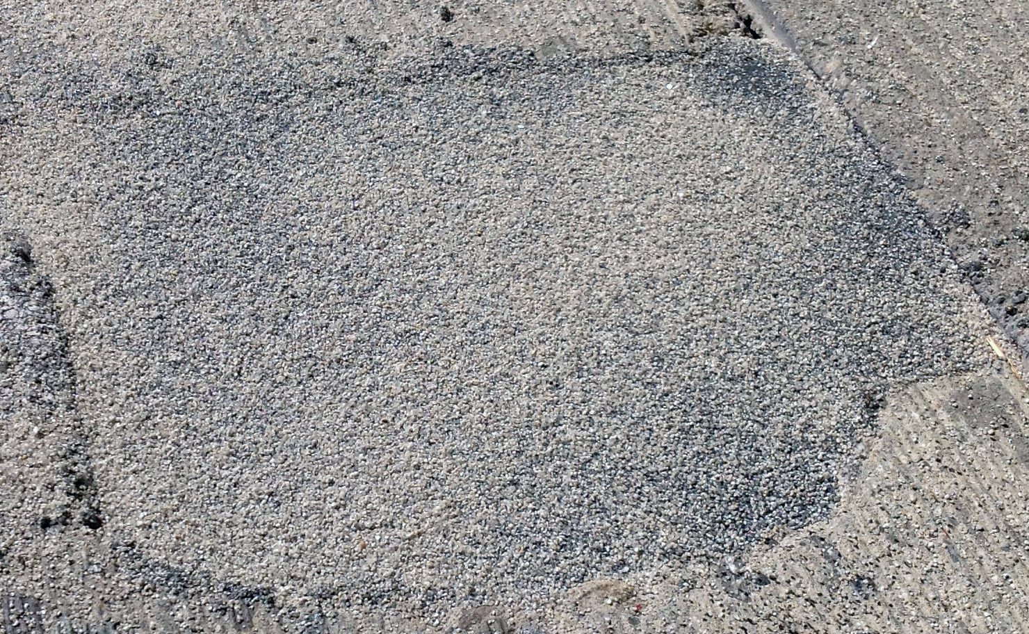 A finished Fast Patch DPR repair, a patch of fine grey aggregate set flush in the surrounding pavement