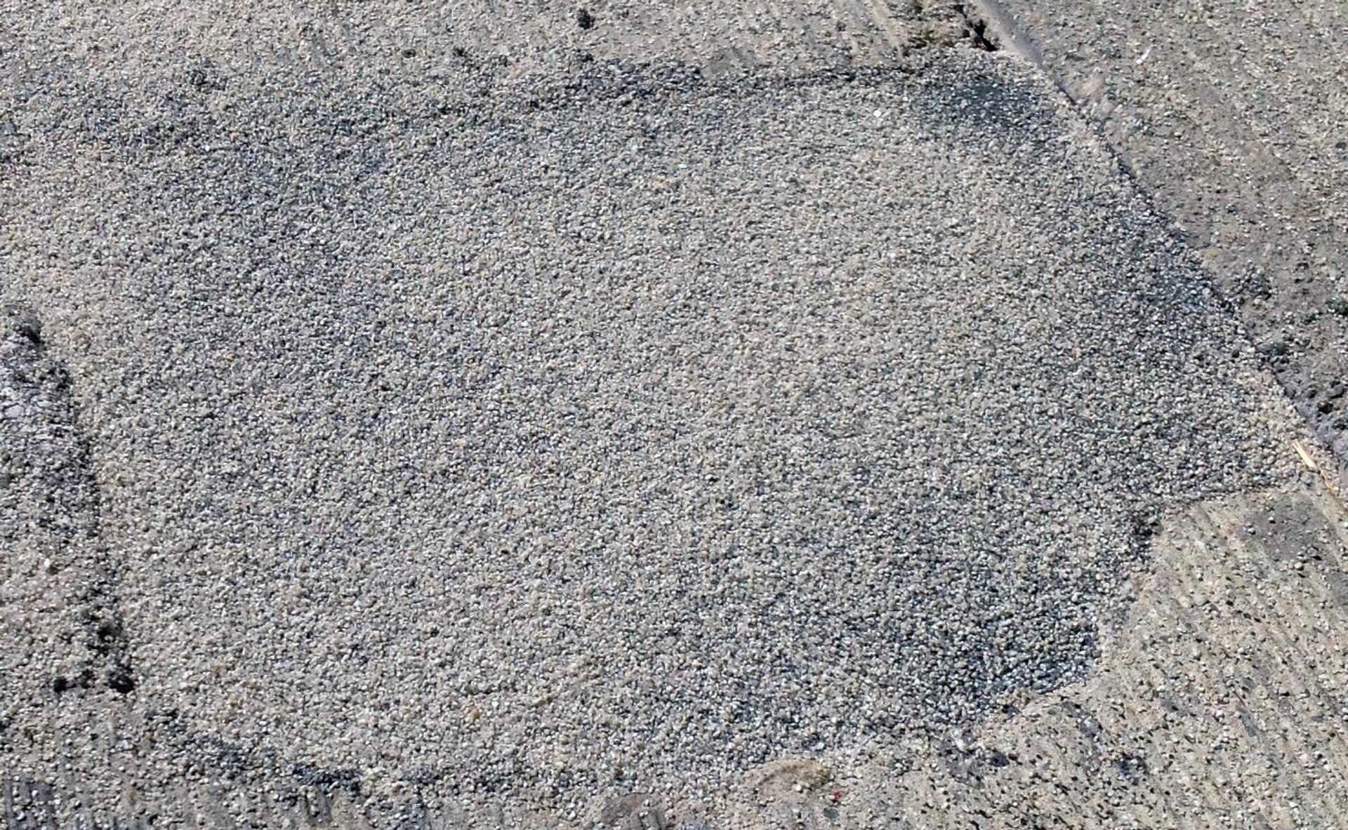A finished Fast Patch DPR repair, a patch of fine grey aggregate set flush in the surrounding pavement