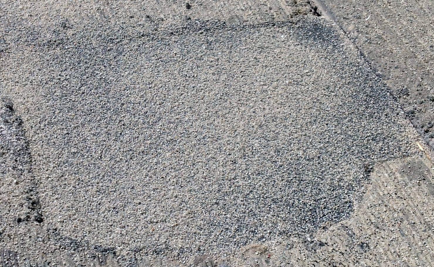 A finished Fast Patch DPR repair, a patch of fine grey aggregate set flush in the surrounding pavement