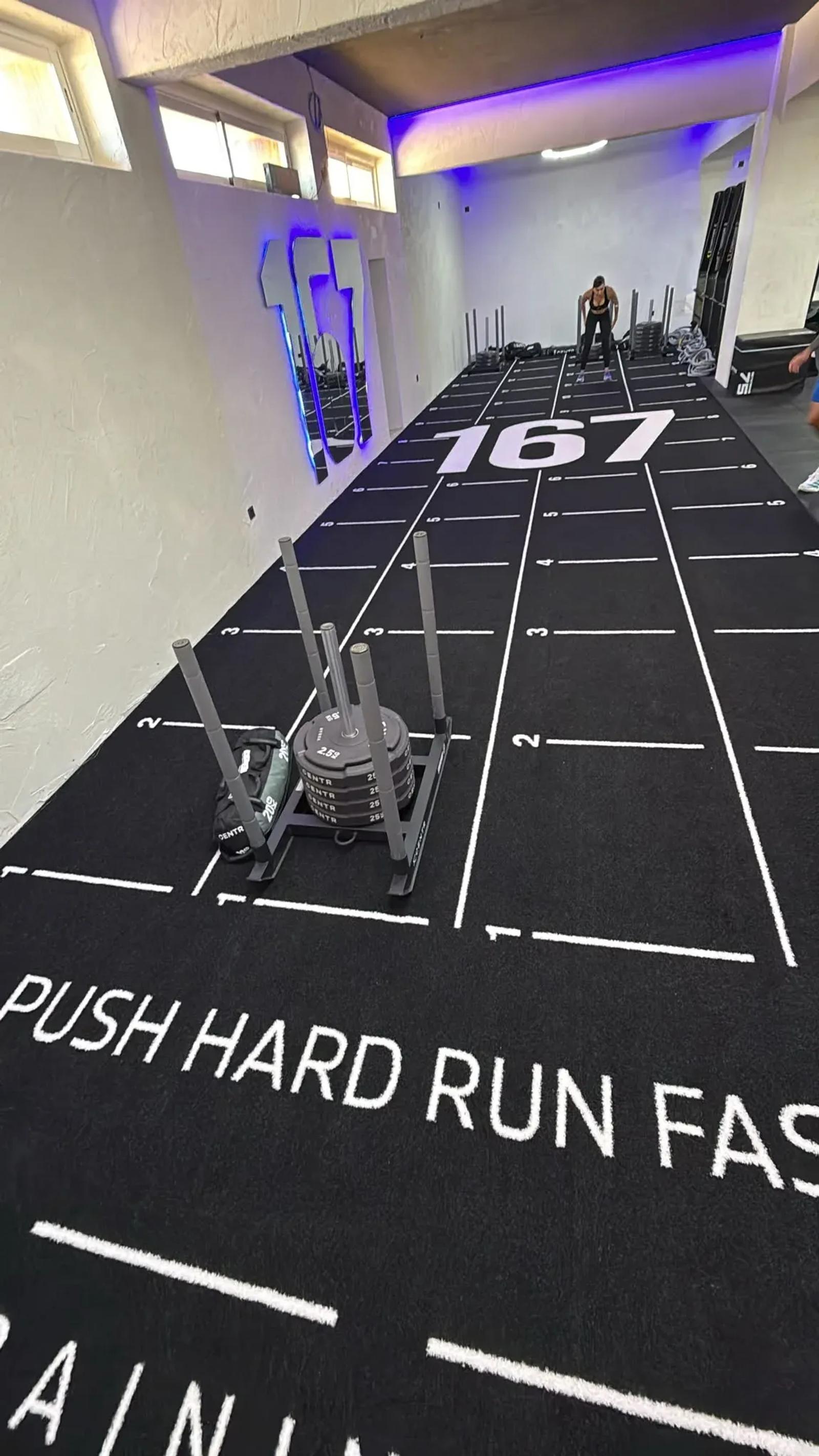  Side view of the black Valhalla lane with the "Push Hard, Run Faster" motto at 167 Training Club