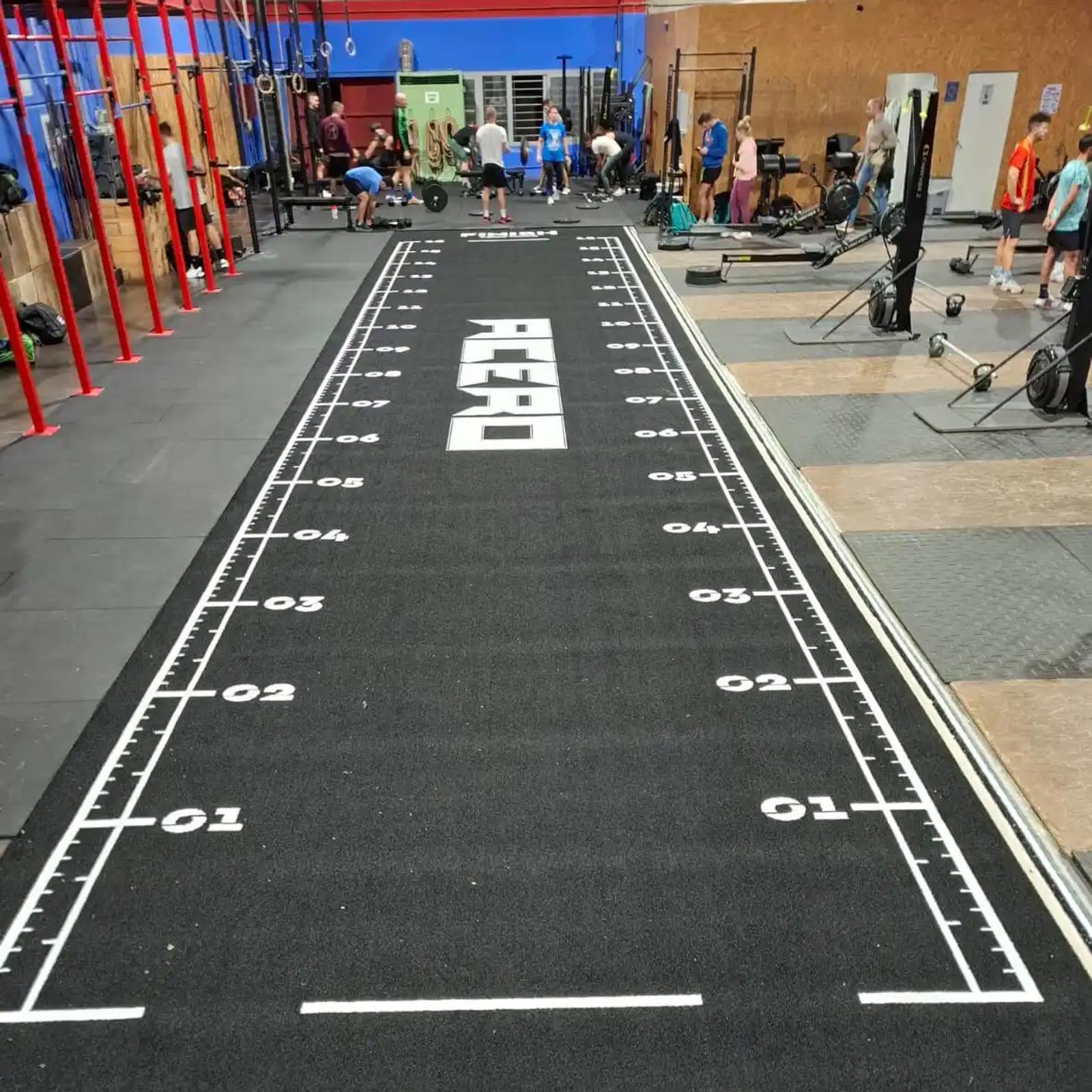 The black XL track running through the Acero CrossFit box with the training rig alongside