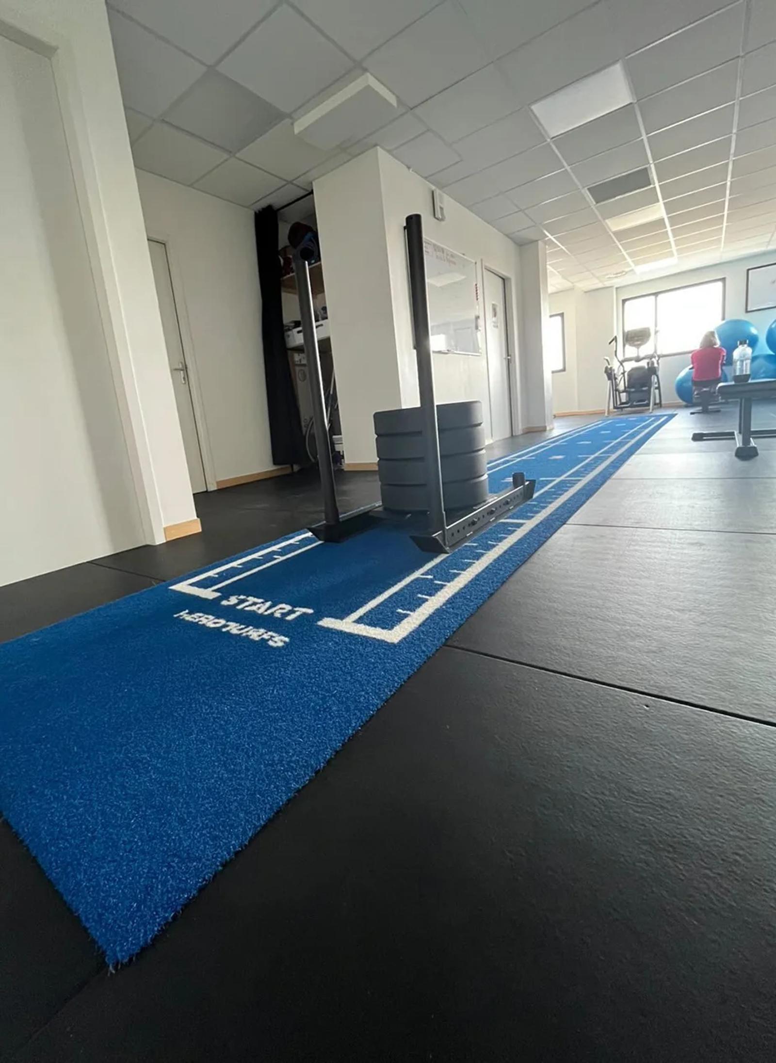 Sled ready to push on the blue Atlantis One lane beside the free weights area in Le Mans