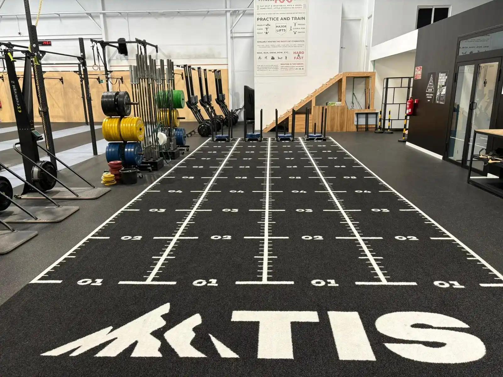 Blue training sleds lined up on the numbered lanes at ATIS CrossFit Telde
