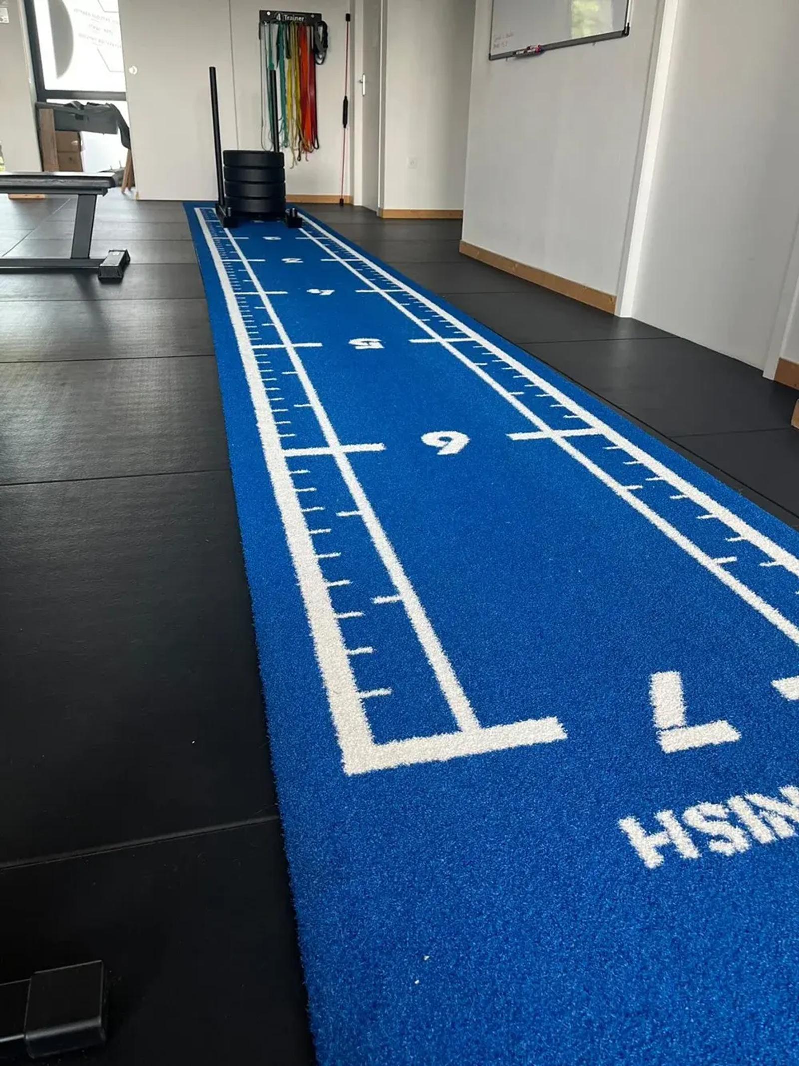 FINISH line and metre markings on the blue Atlantis One track at Centre Santé & Performance, Le Mans