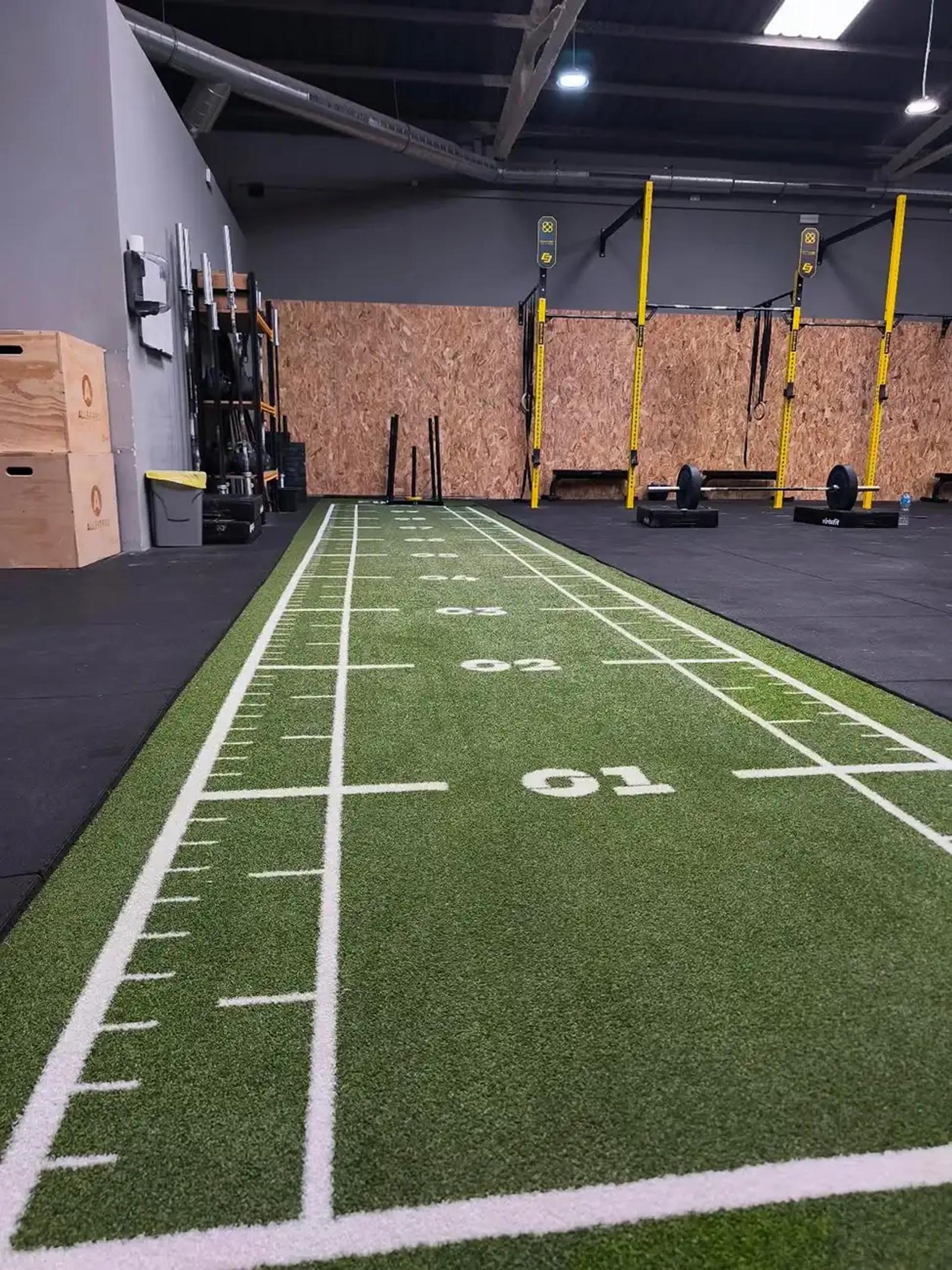 Angled view of the green Heroturfs track installed on the Boxcelona gym floor