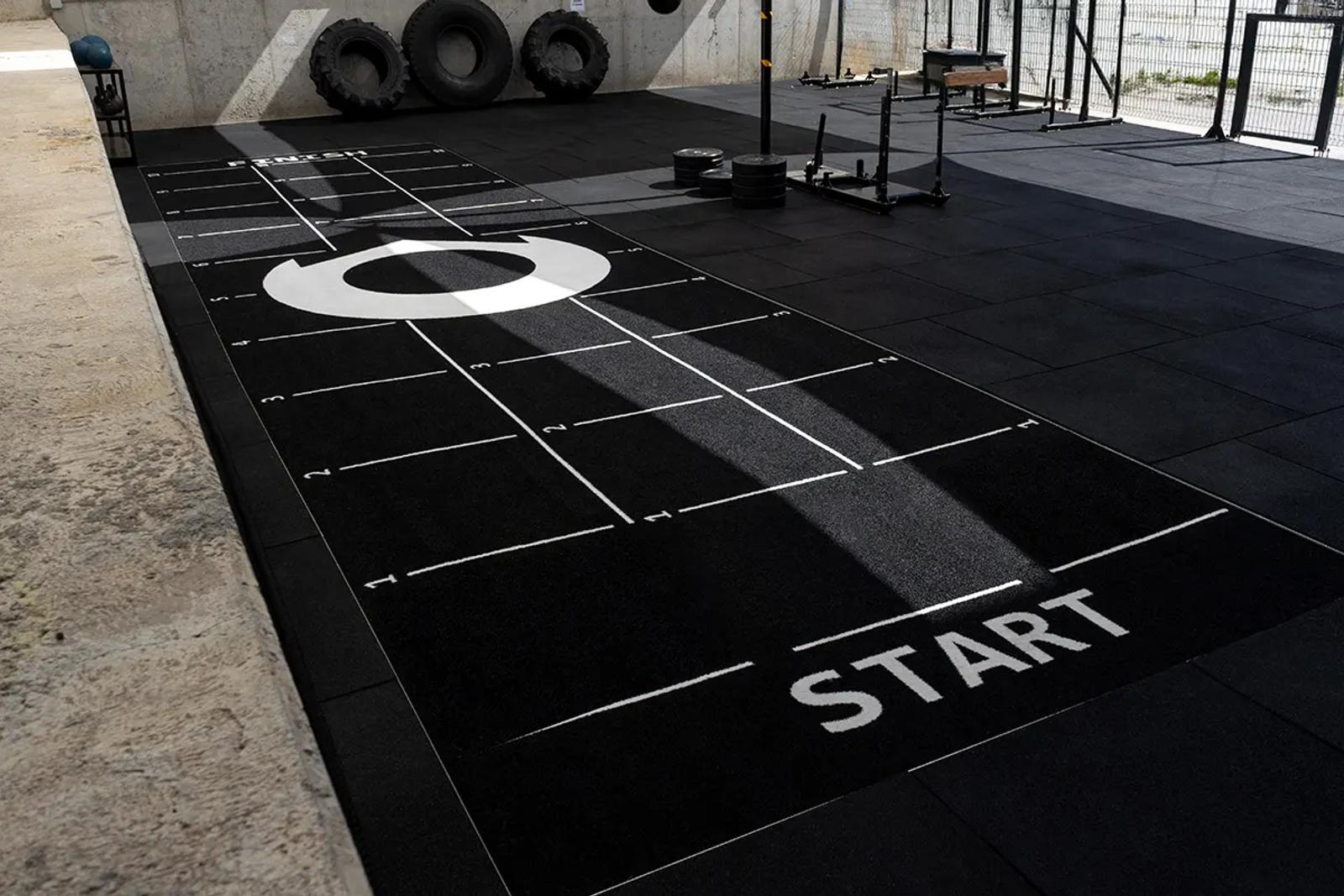 Grid markings along the black sled push track at Oxygen, Málaga