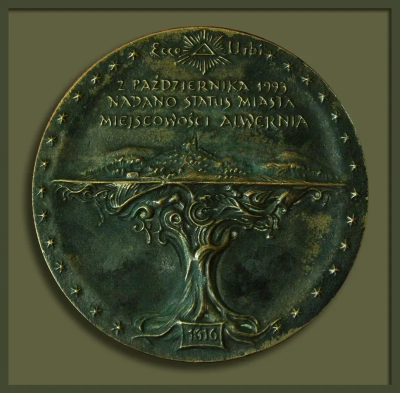 Okrągły medal z napisem dotyczącym Alwerni, rozgałęzionym ornamentem i gwiazdami przy brzegu.