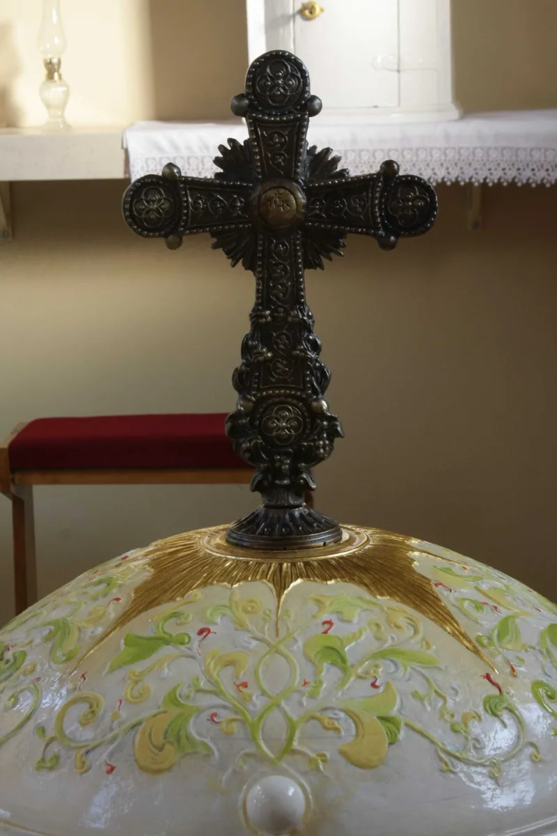 Ozdobny krzyż na kopulastej pokrywie chrzcielnicy.