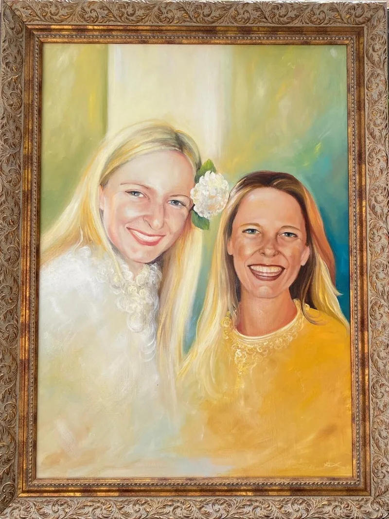 Podwójny portret dwóch uśmiechniętych kobiet w ozdobnej ramie.