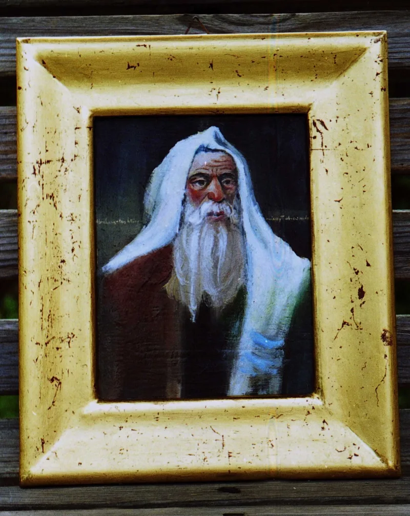 Portret siwego, brodatego mężczyzny w jasnym nakryciu głowy, w złocistej ramie.