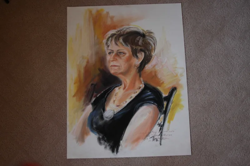 Portret kobiety z krótkimi włosami, siedzącej w ciemnej sukience.