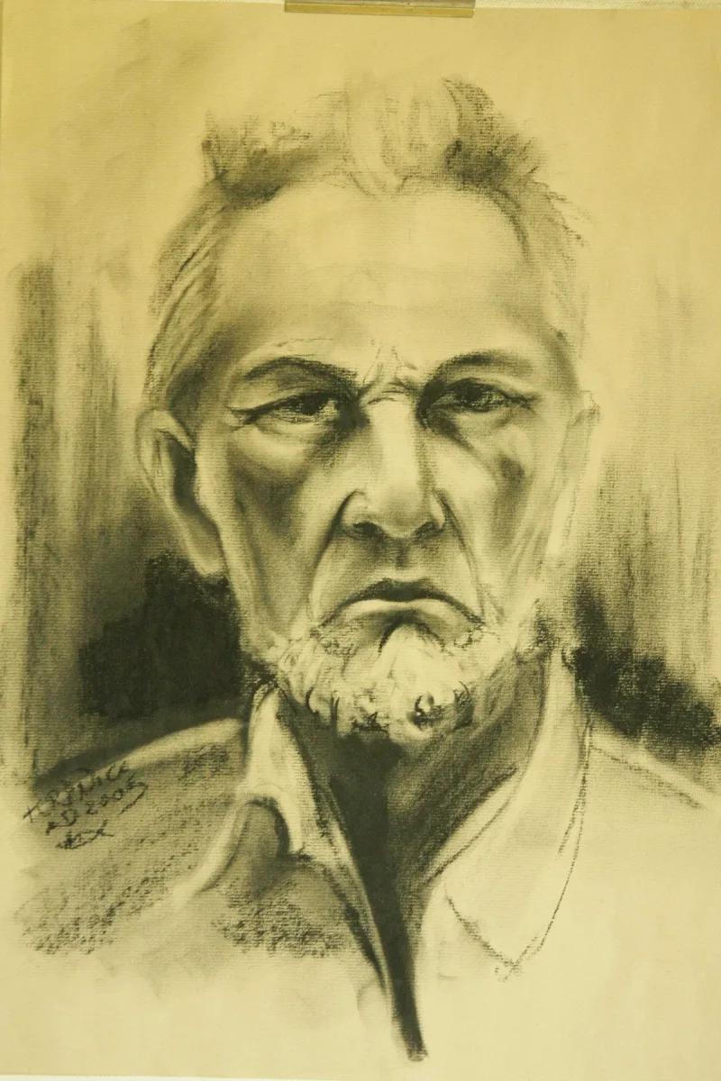 Frontalny portret mężczyzny z krótką brodą i zmarszczonym czołem.