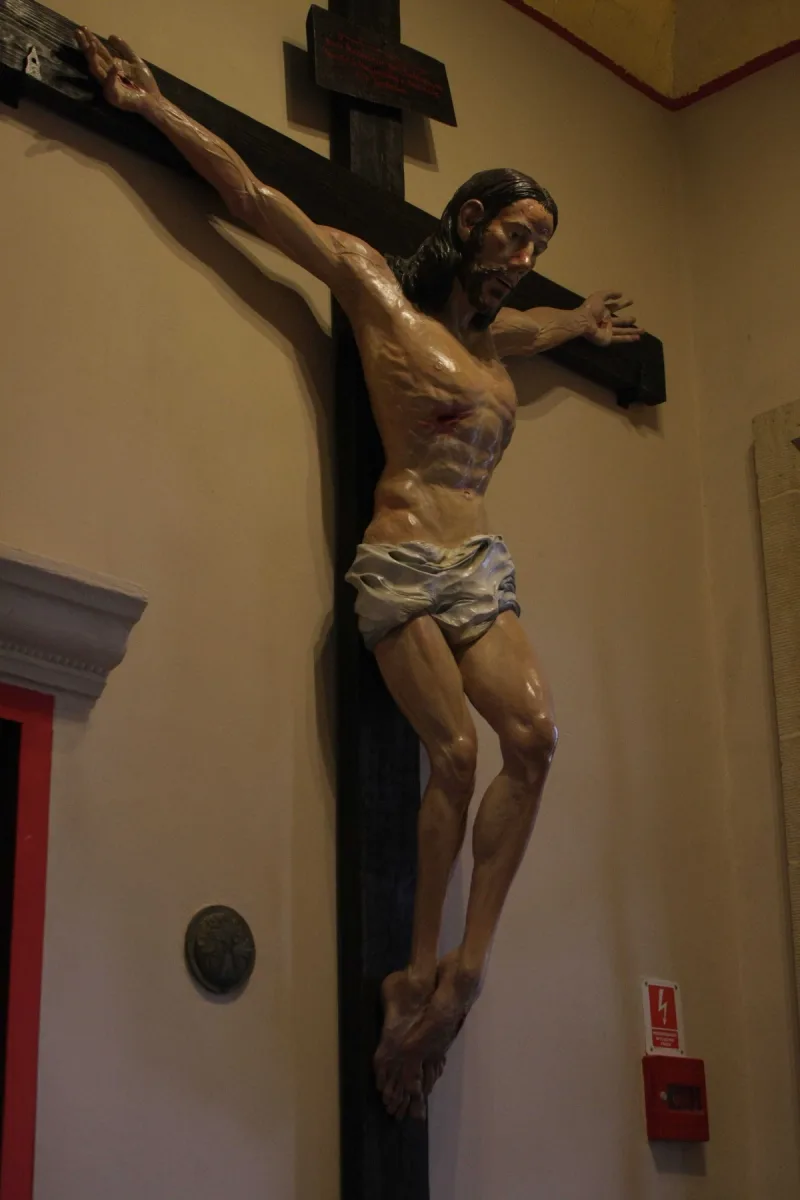 Figura Chrystusa z rozłożonymi ramionami, umieszczona na krzyżu we wnętrzu kościoła.