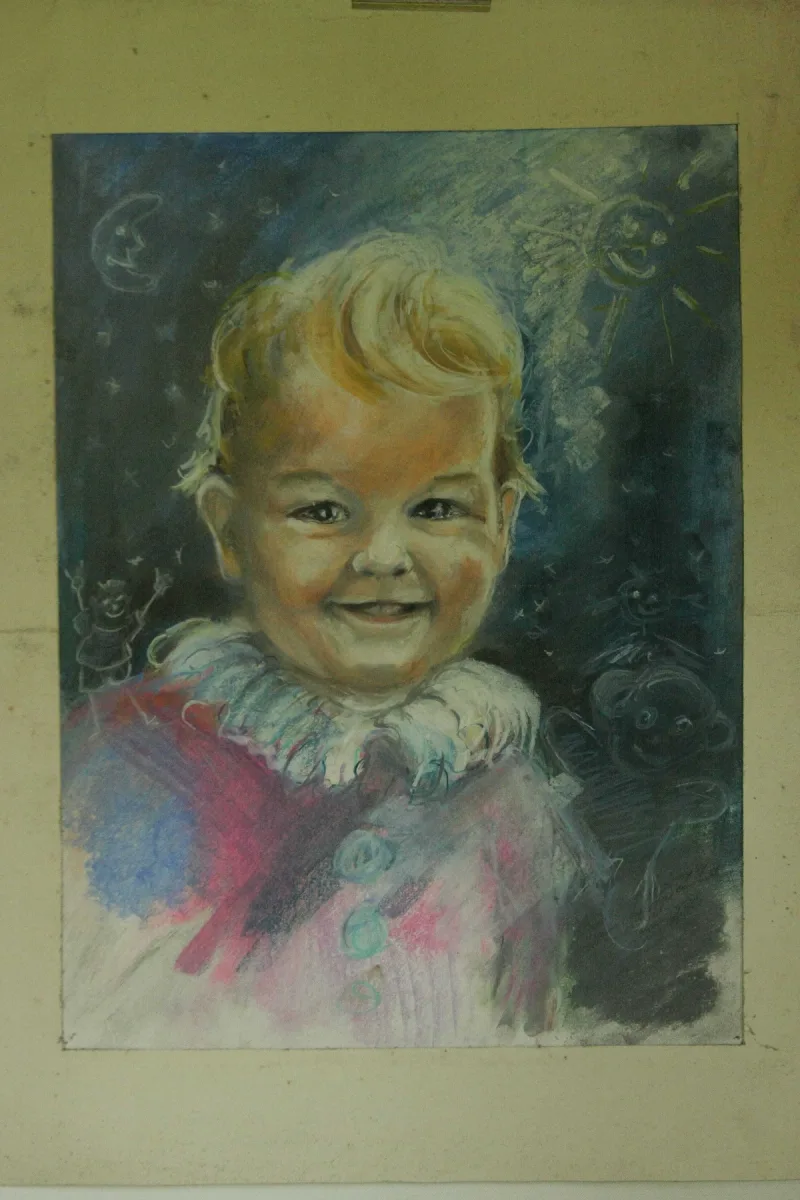 Barwny portret uśmiechniętego dziecka z jasnymi włosami.