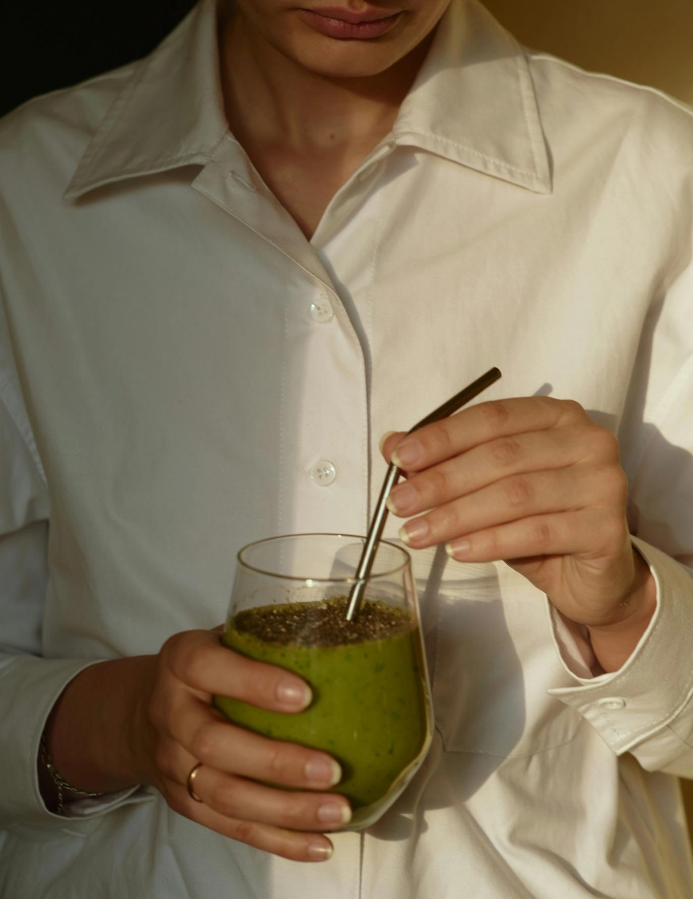 Woman in white shirt drinking smoothie