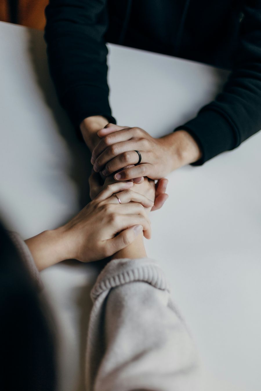 Women holding hands in support - support is crucial in cancer care