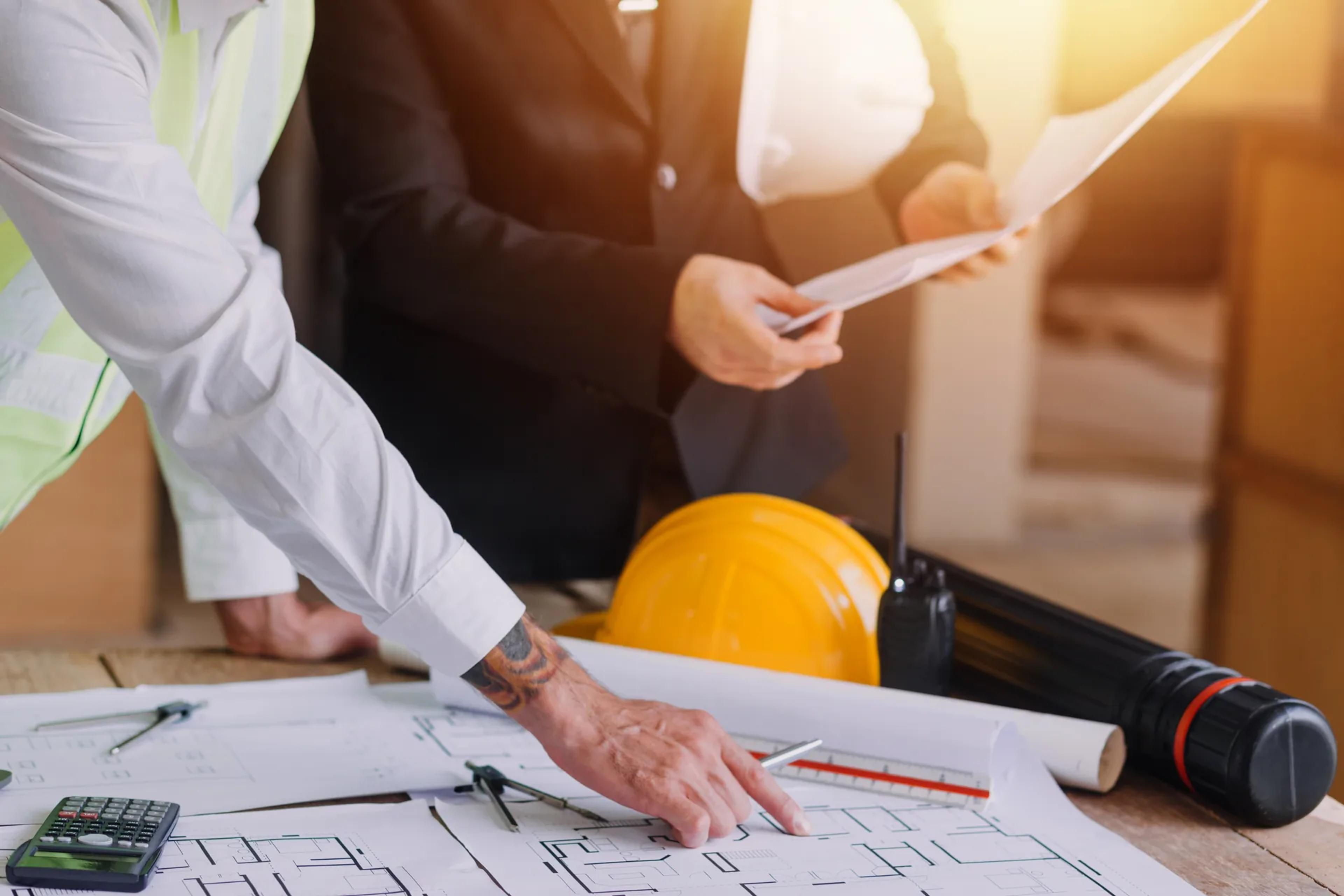 Licensed engineer reviewing electrical drawings and project records with a client during a forensic engineering case review