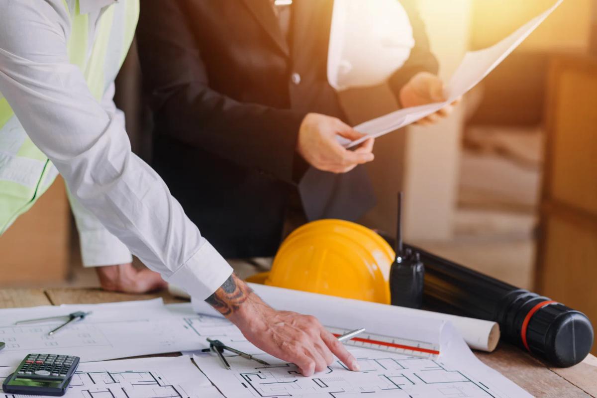 Licensed engineer reviewing electrical drawings and project records with a client during a forensic engineering case review