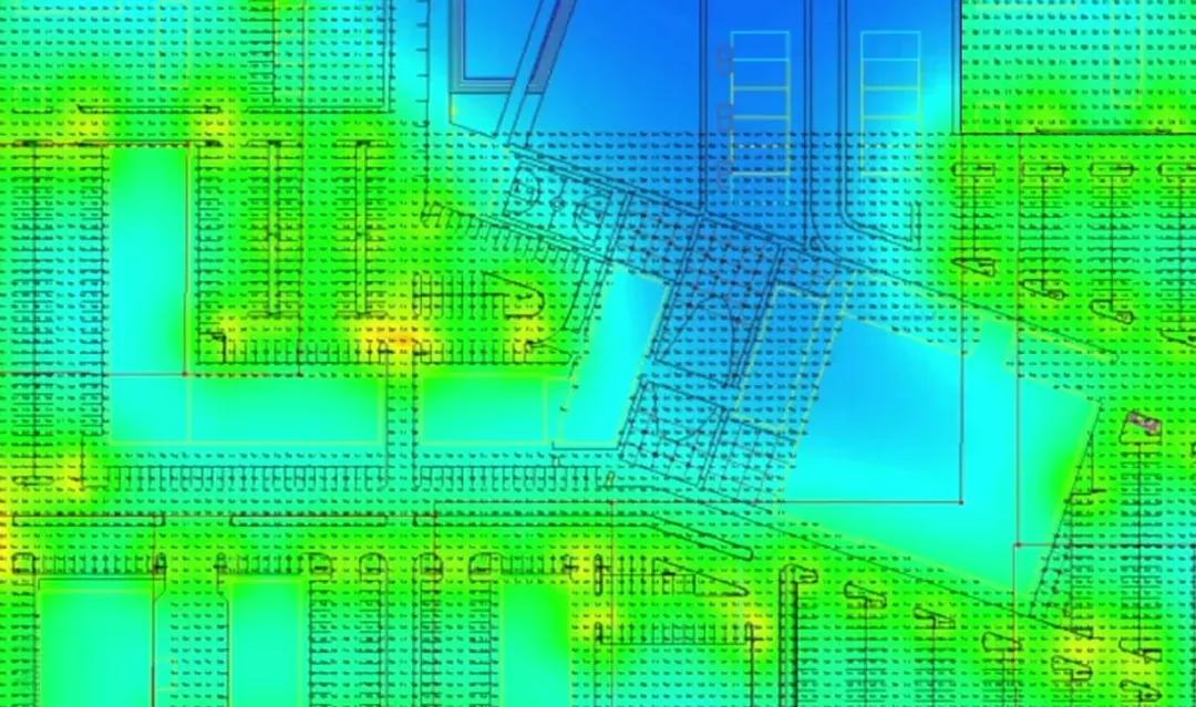 False-color photometric analysis rendering of a site lighting plan showing calculated illuminance levels across parking areas and buildings
