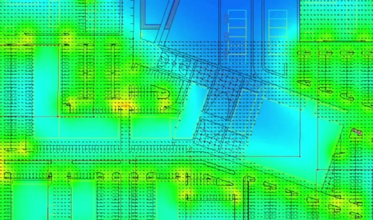 False-color photometric analysis rendering of a site lighting plan showing calculated illuminance levels across parking areas and buildings
