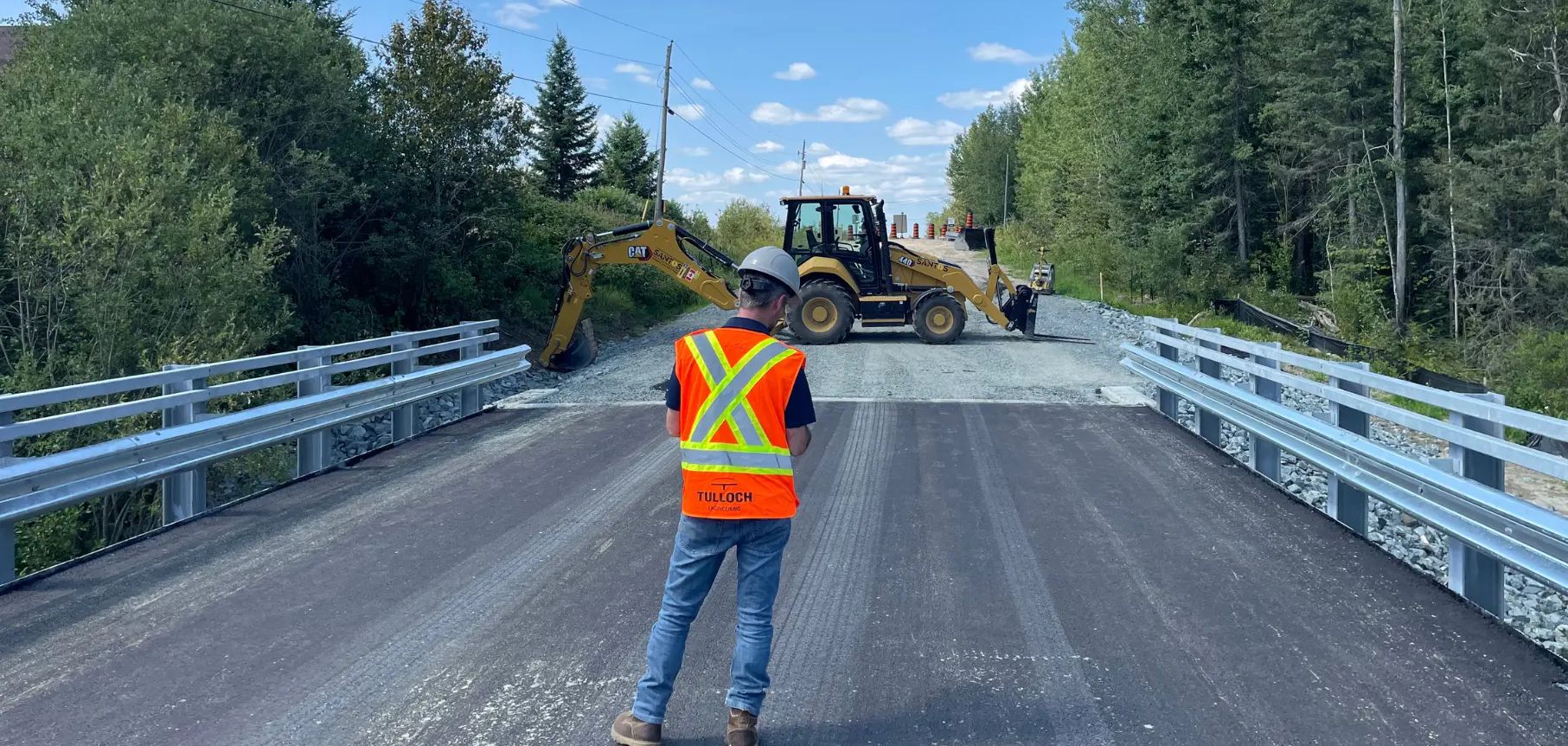 TULLOCH field technician completing a bridge inspection on a roadway.