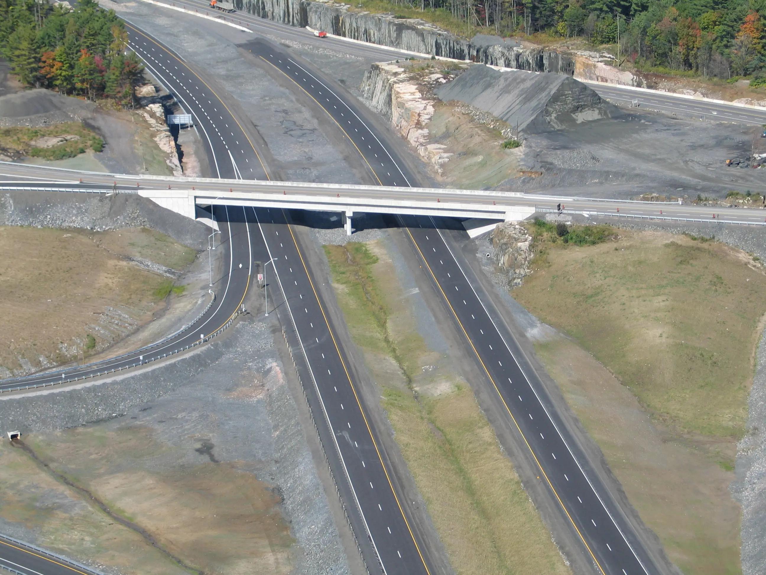 Aerial view of a highway interchange and bridge corridor.