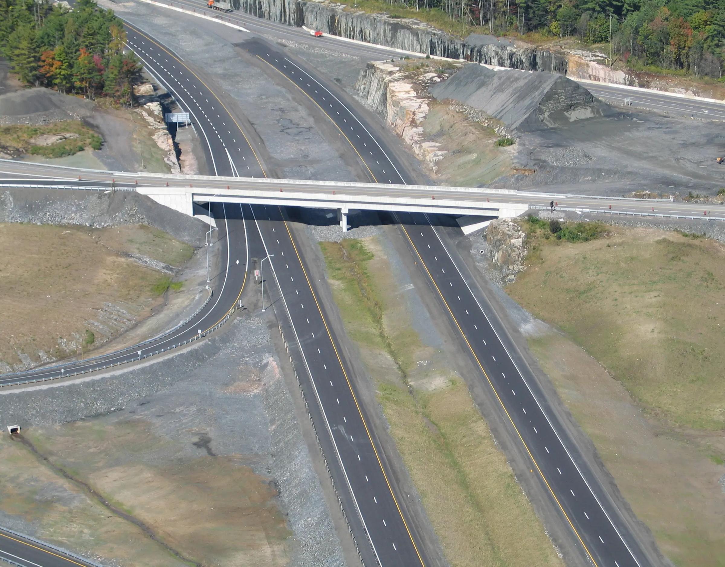 Aerial view of a highway interchange and bridge corridor.