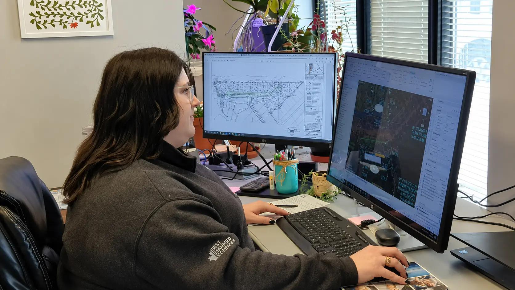 TULLOCH planner working with technical drawings at a computer.