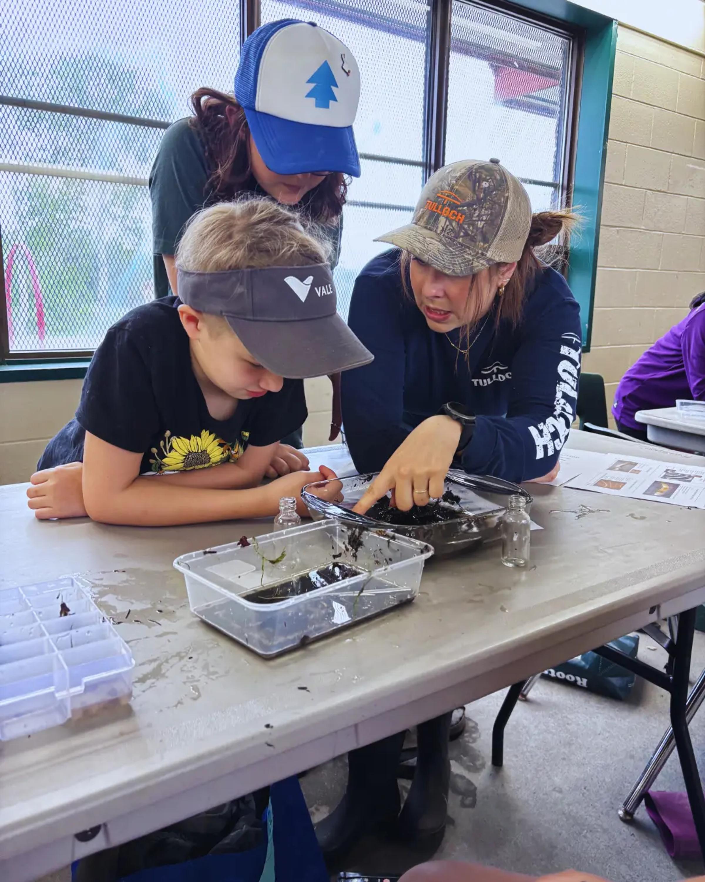 Youth participants examining benthic samples during a hands-on environmental activity.