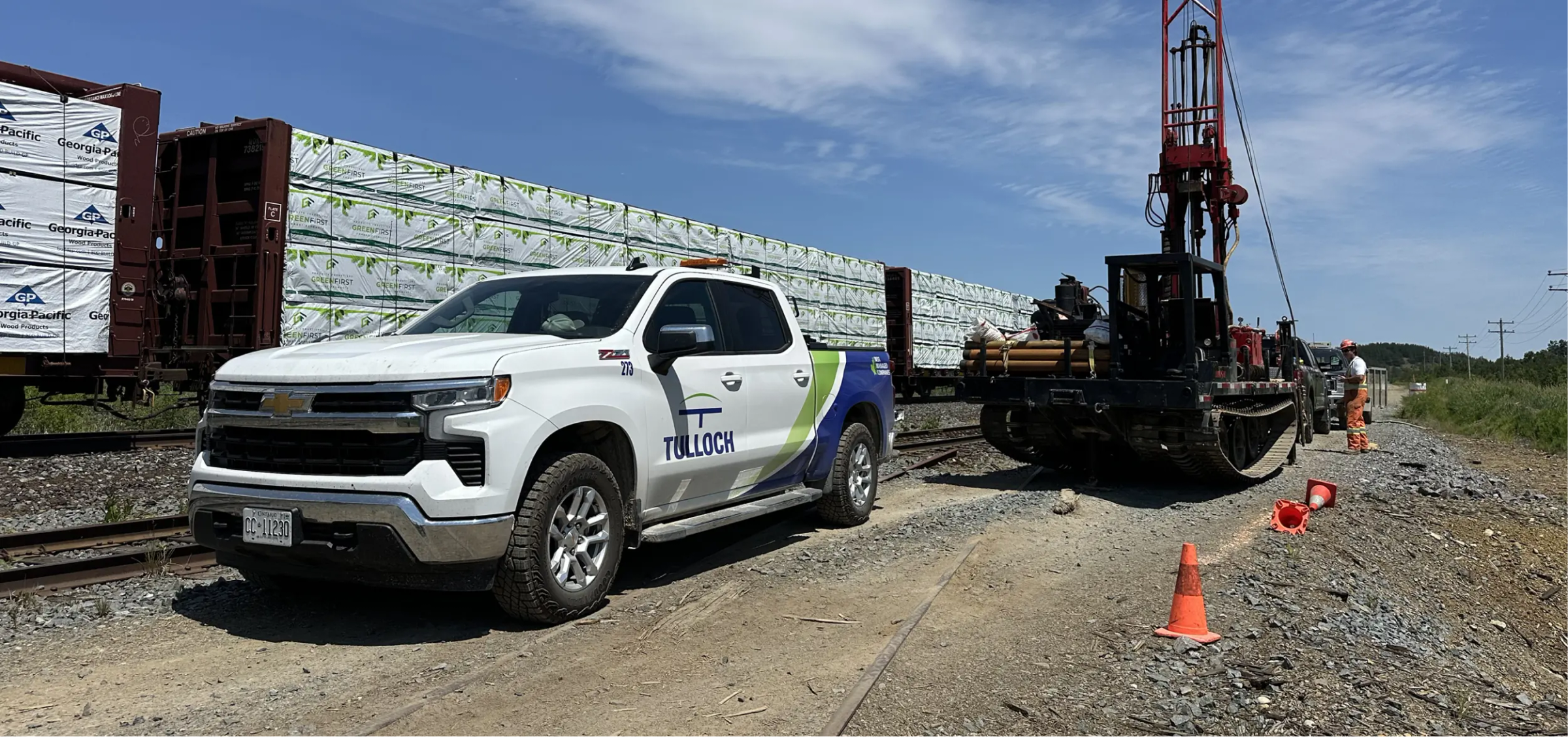 TULLOCH company truck beside geotechnical drilling equipment at a project site.