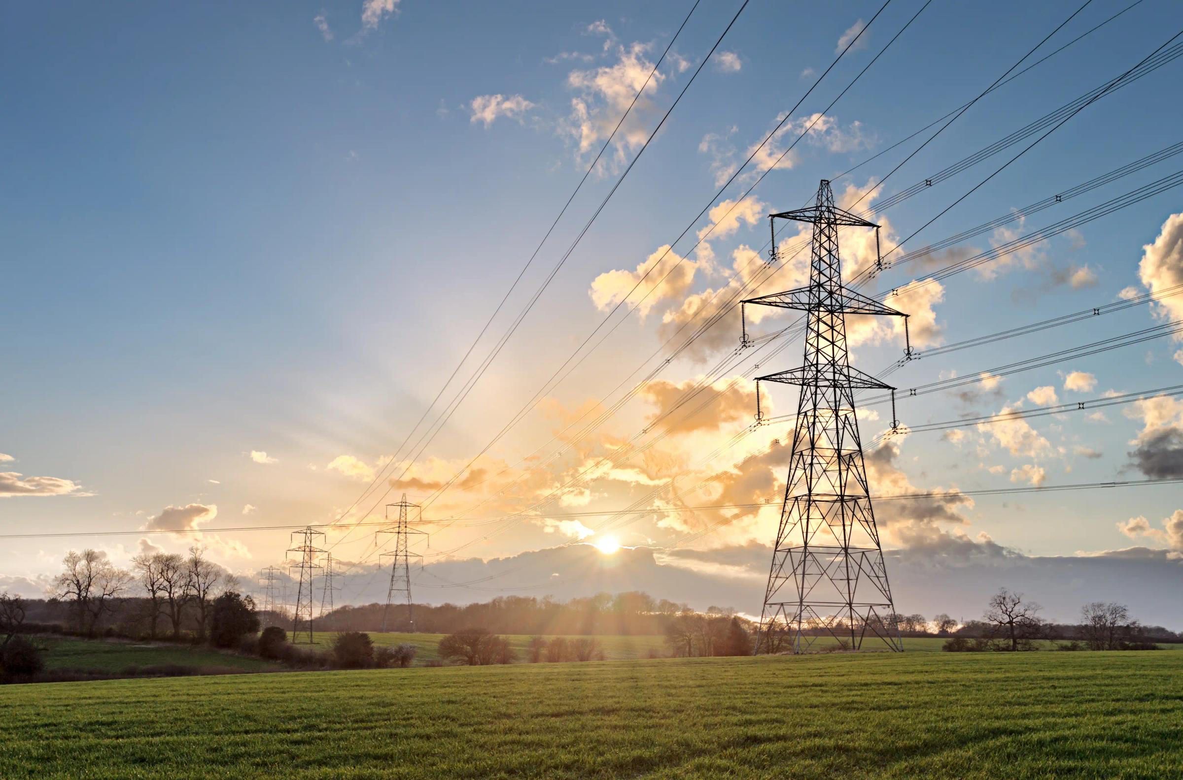 High-voltage transmission line infrastructure across an open landscape.