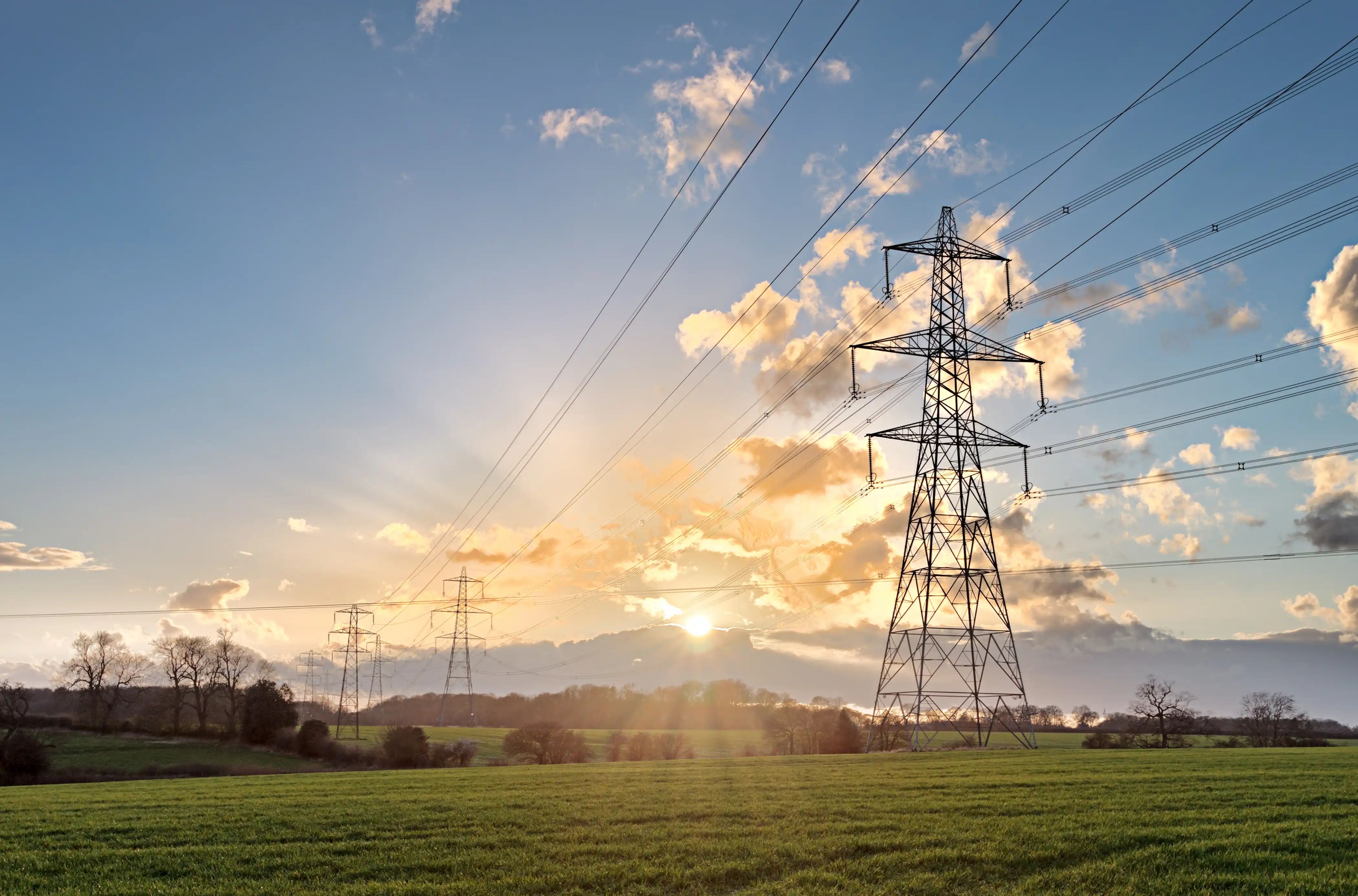 High-voltage transmission line infrastructure across an open landscape.