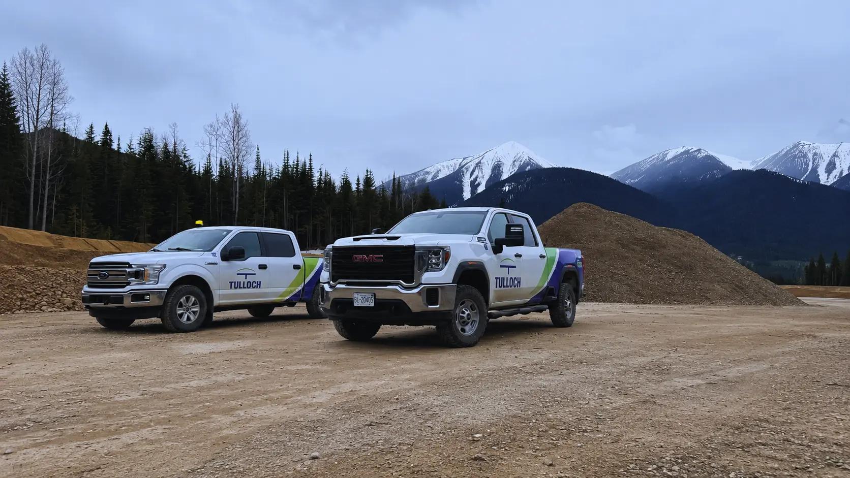 TULLOCH company trucks at a Western Canada project site with mountains in the background.