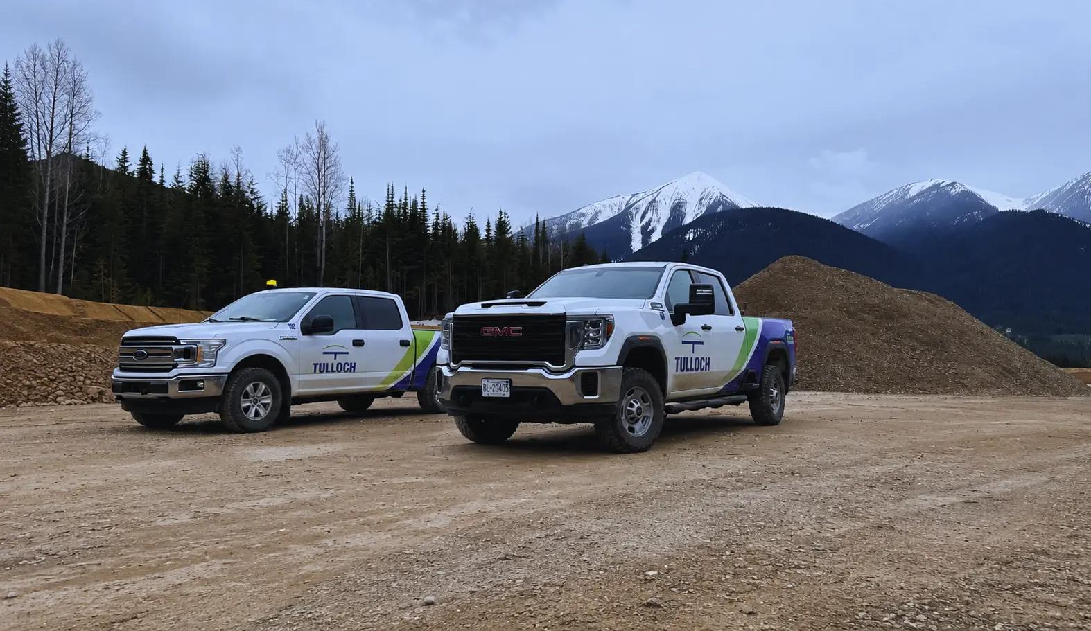 TULLOCH company trucks at a Western Canada project site with mountains in the background.