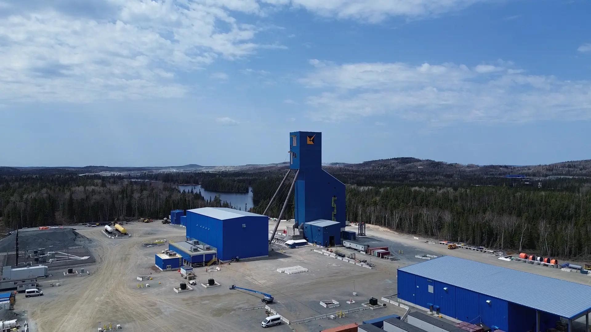 Aerial view of a mine processing facility surrounded by forest.