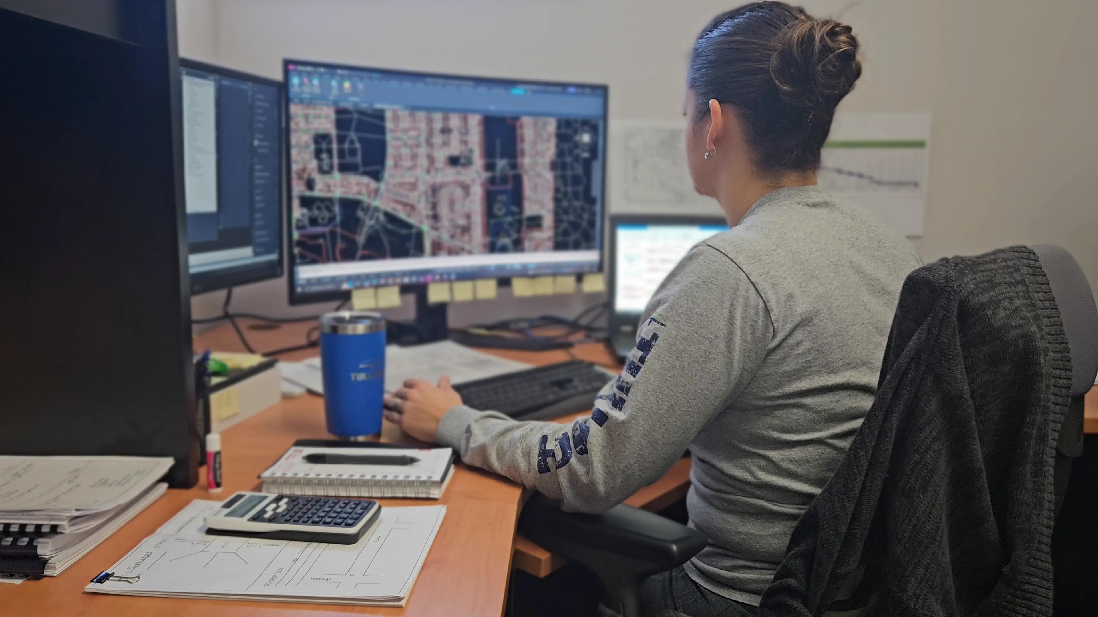 TULLOCH engineering team member reviewing project information at a workstation.