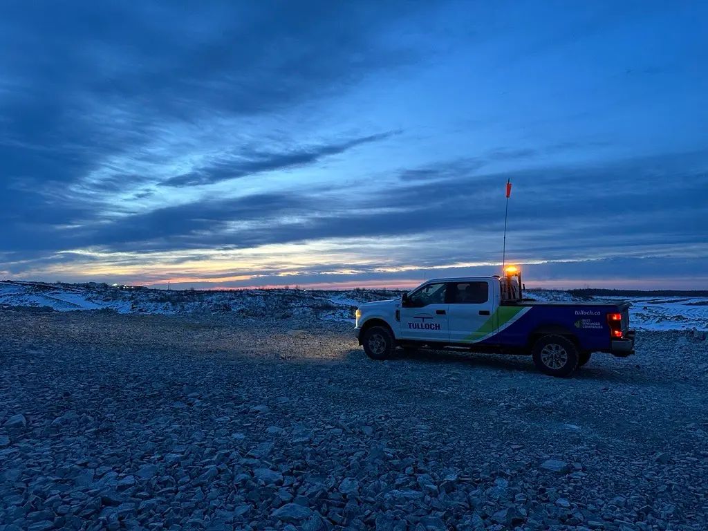 TULLOCH company truck parked at a remote project site at sunset.