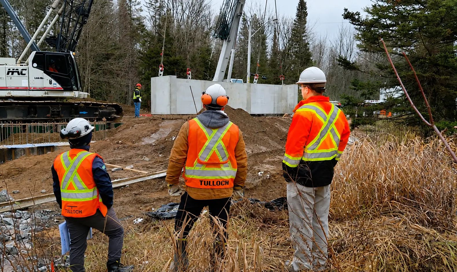 TULLOCH field team reviewing conditions near a bridge project.