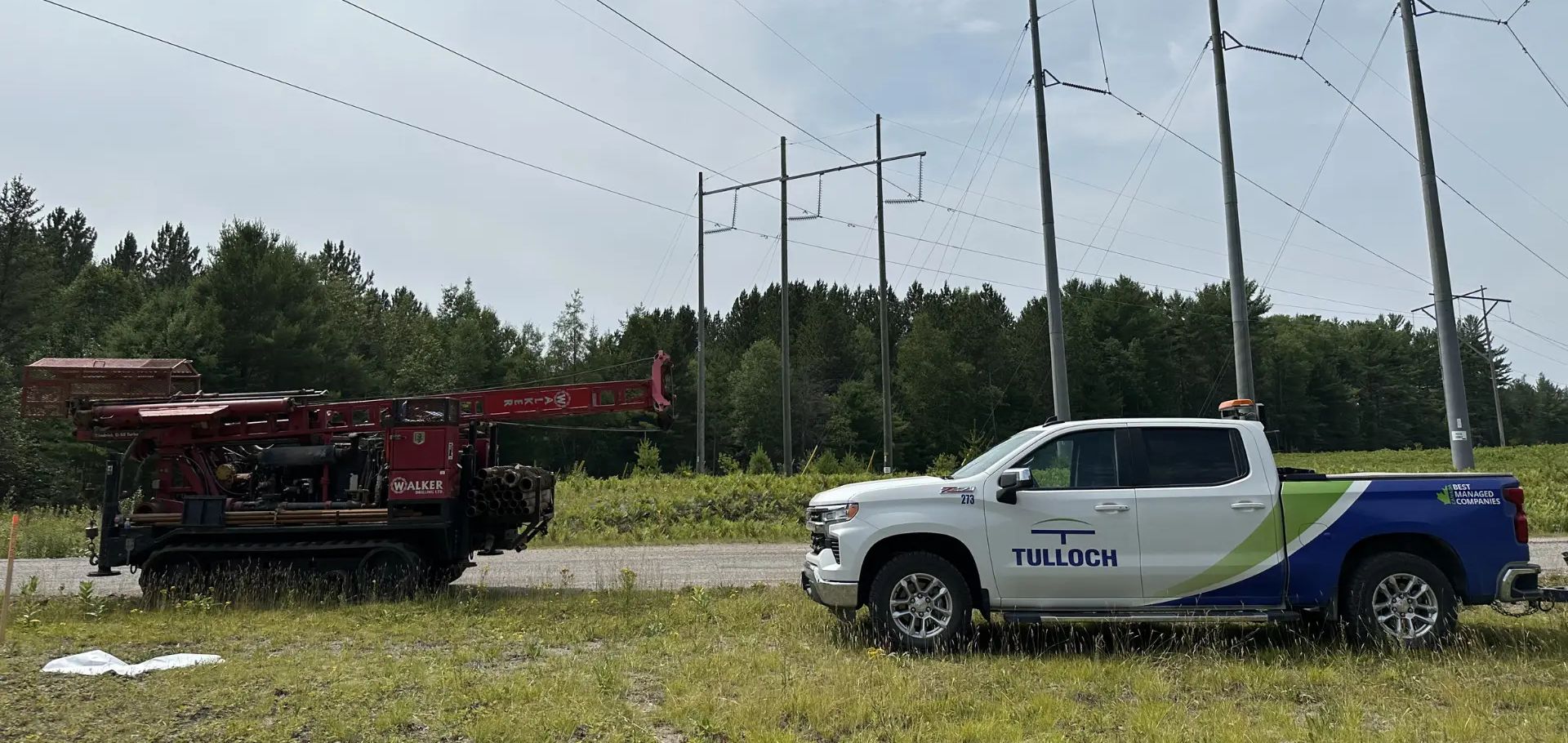 TULLOCH truck at transmission corridor project with geotechnical equipment.