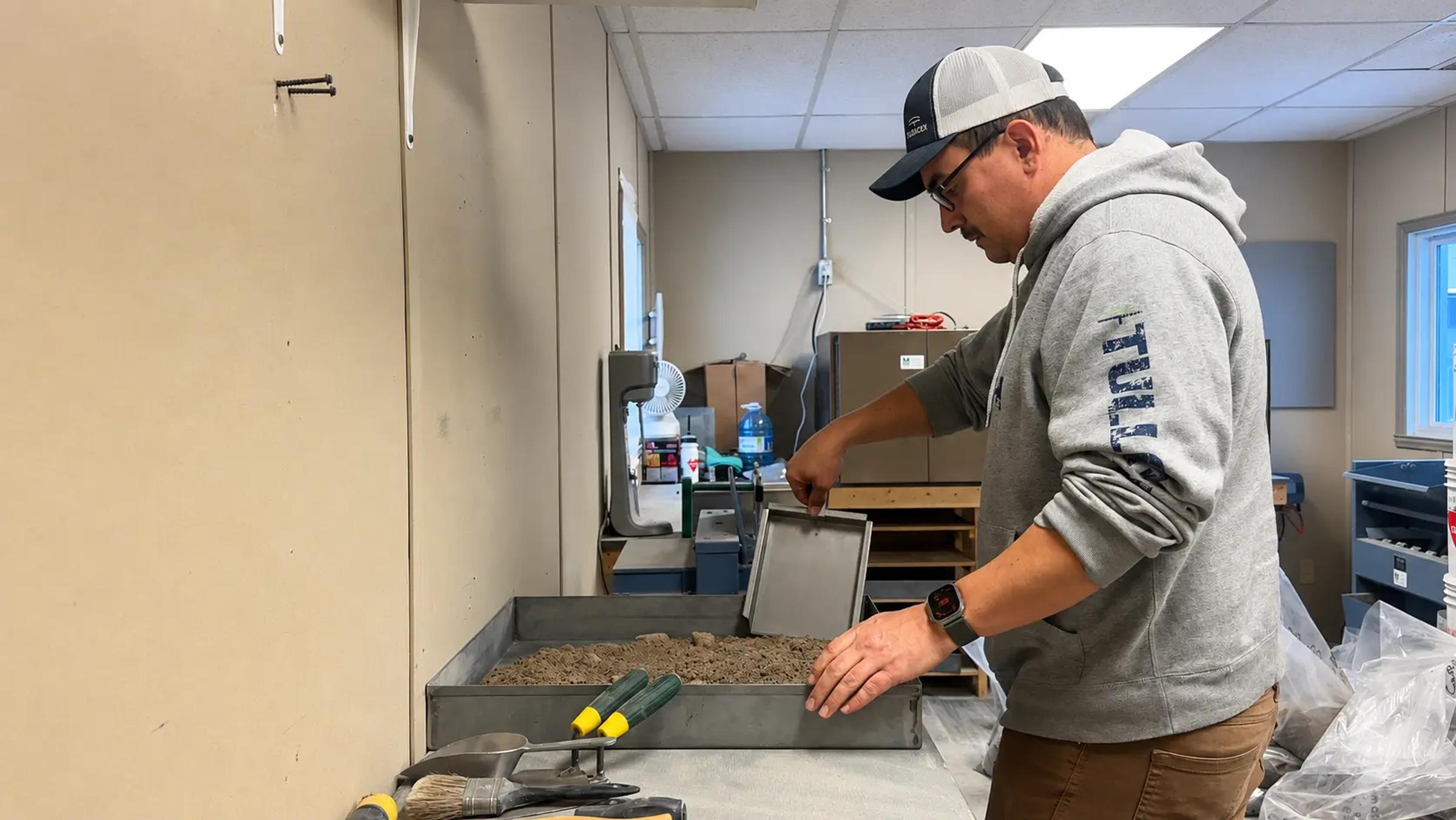 TULLOCH laboratory technician preparing sand for materials testing.
