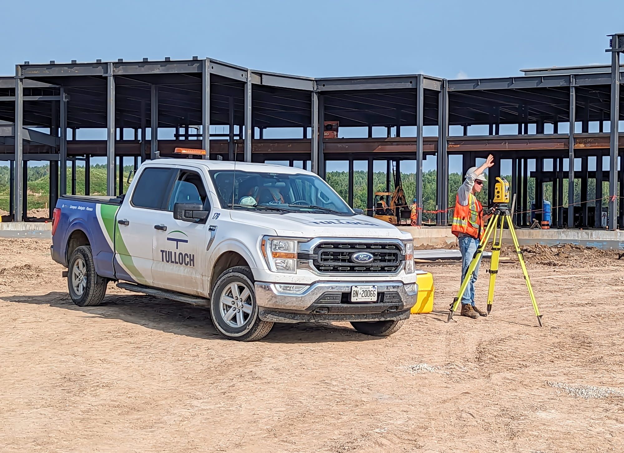 TULLOCH company truck and survey equipment at an active construction site.