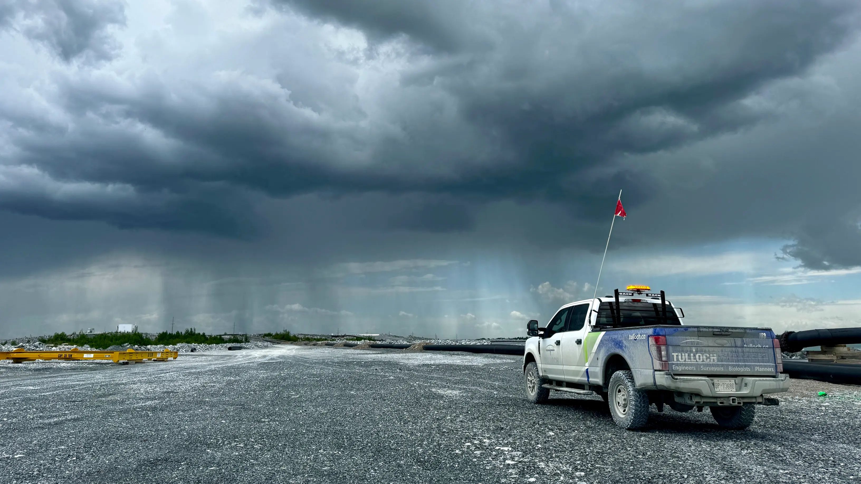 TULLOCH company truck at an active mine site under storm clouds.