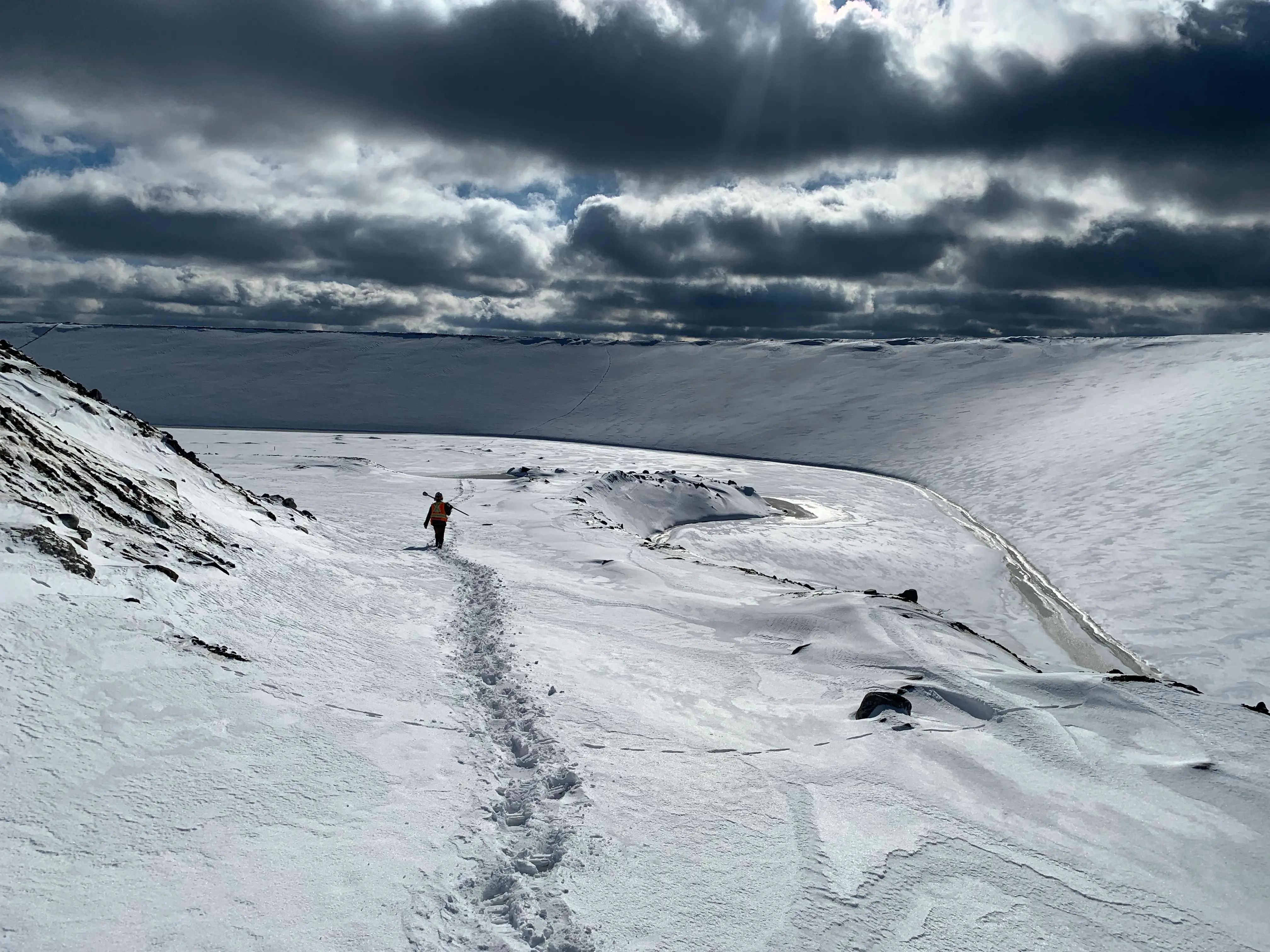 TULLOCH field technician working across a snow-covered area at the Magino mine.